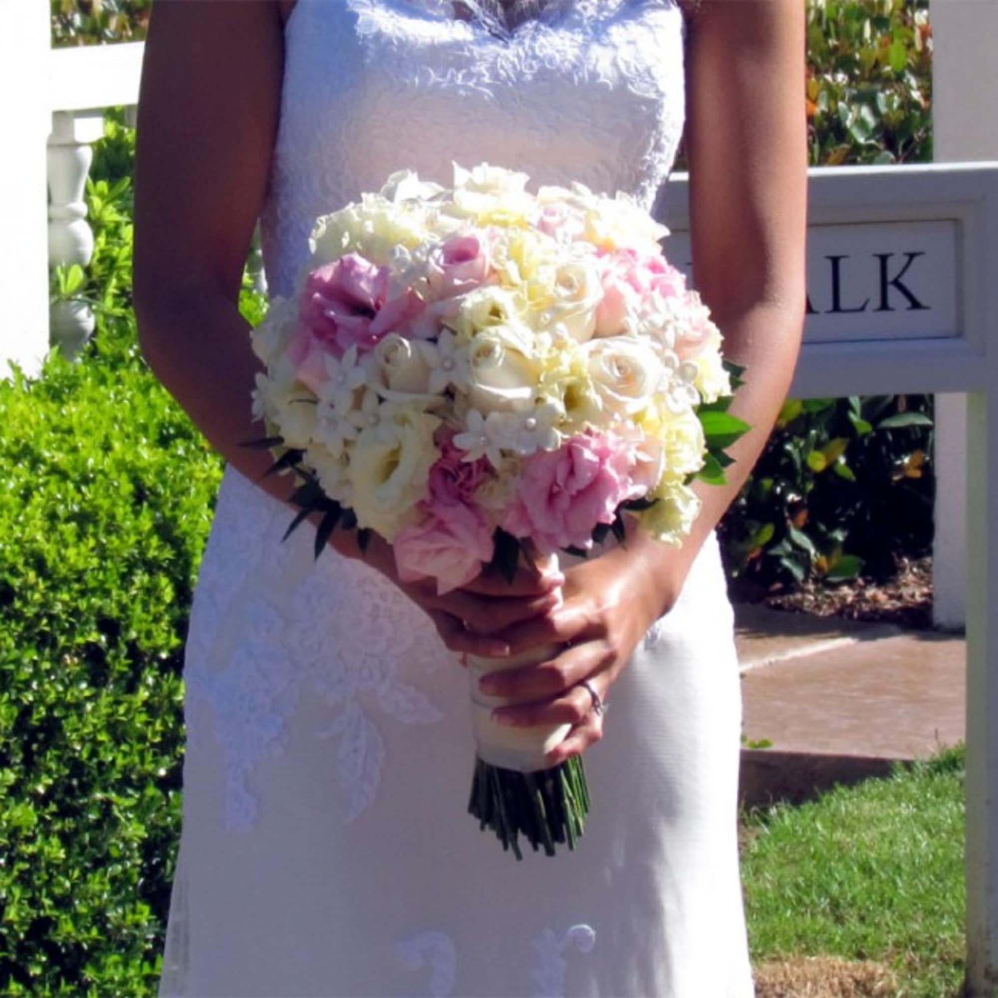 Bride holding a round bouquet of pink and white flowers
