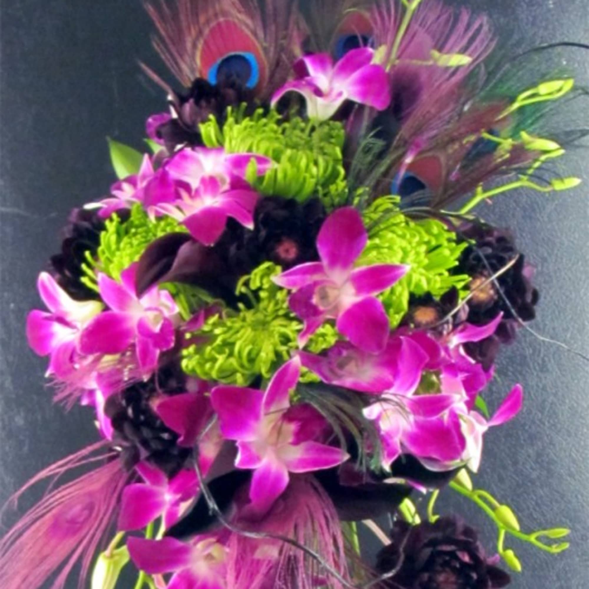 Bouquet of purple orchids with bright green blooms and peacock feathers