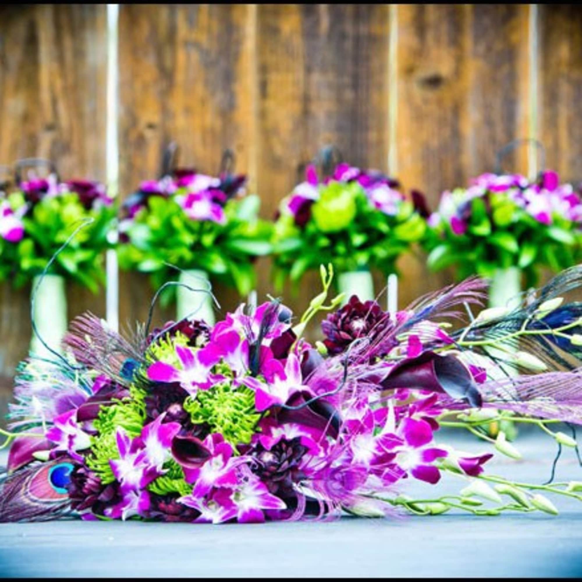 Purple orchid bouquet with peacock feathers on a table