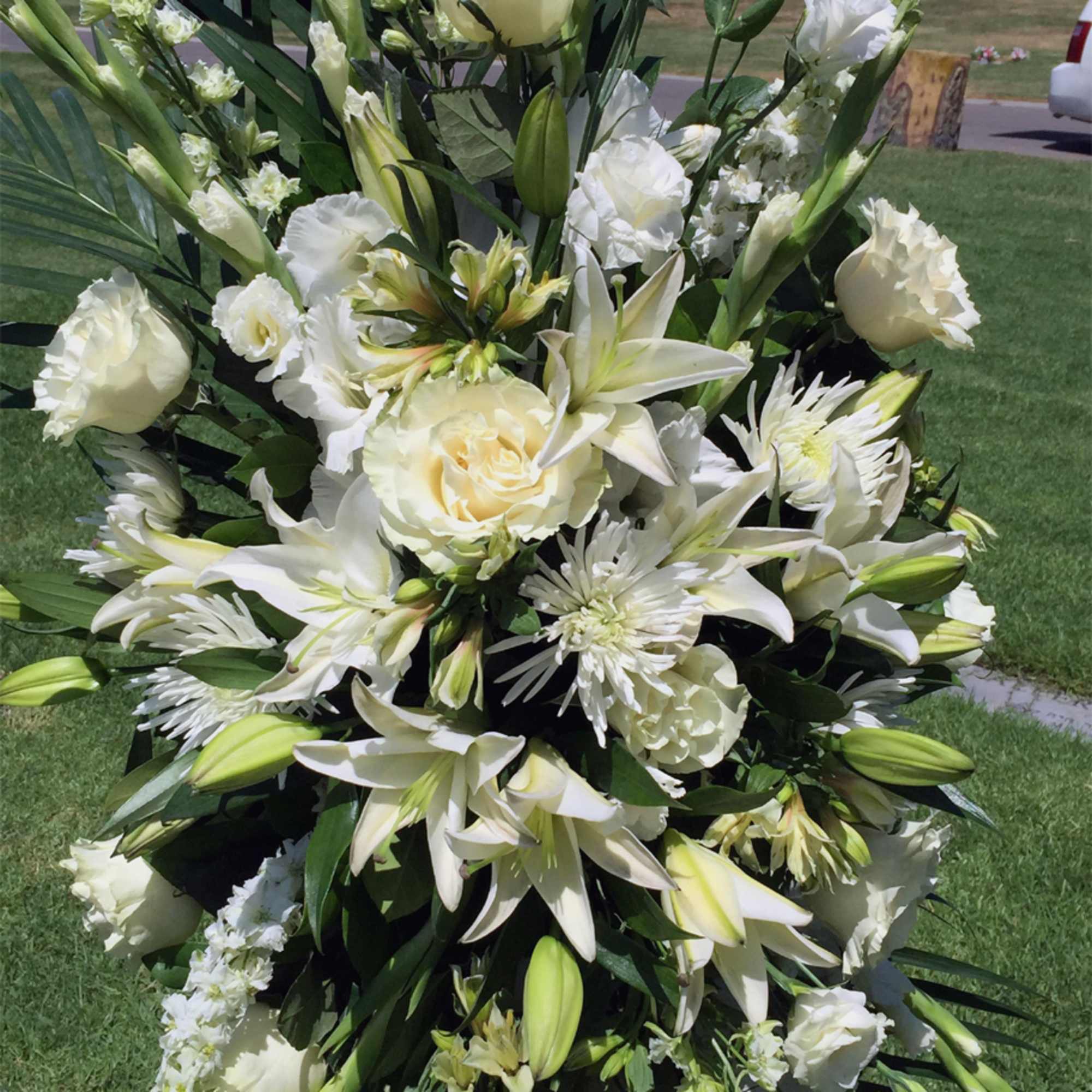 Large white floral standing spray with lilies and roses