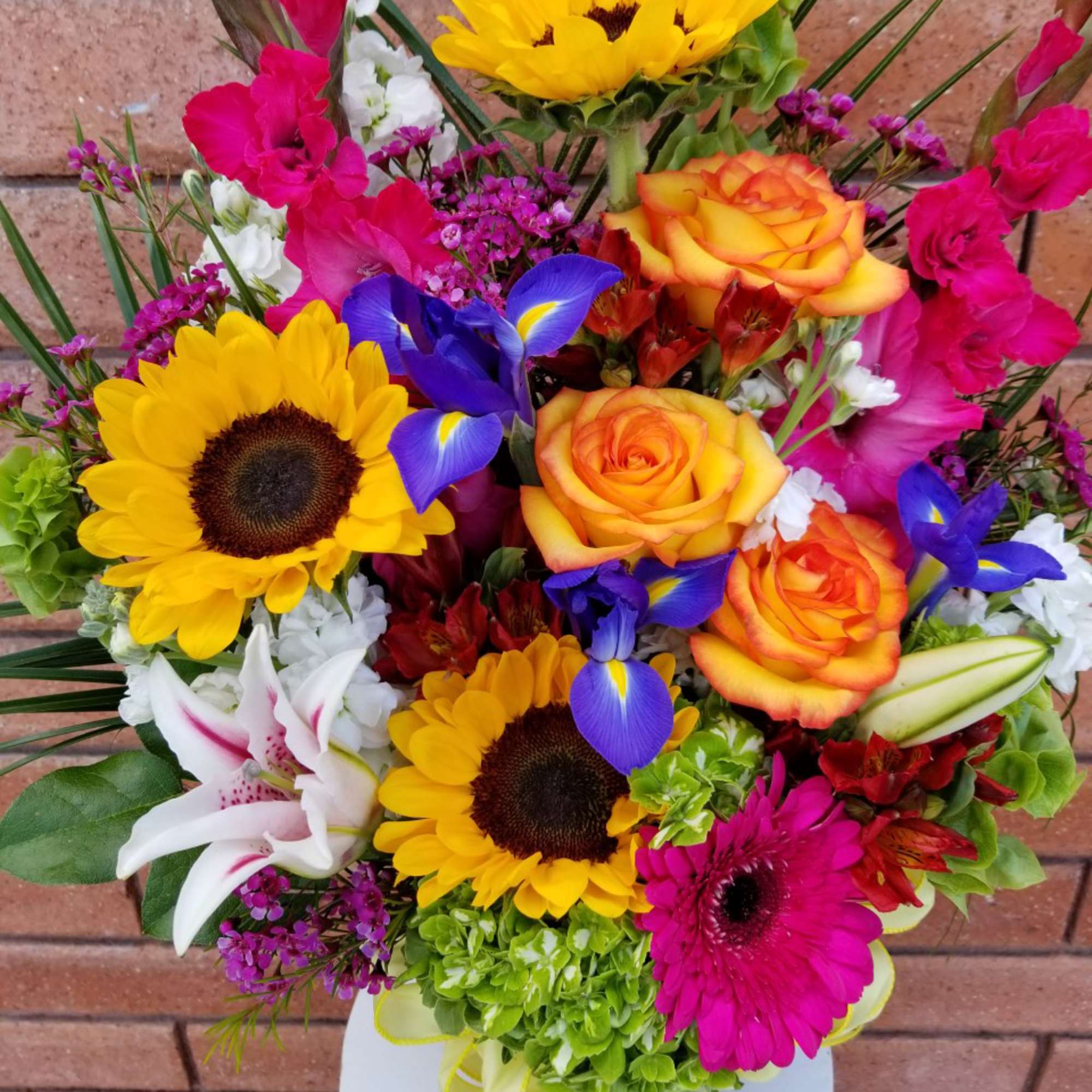 Bright mixed bouquet with sunflowers, roses, irises, and lilies