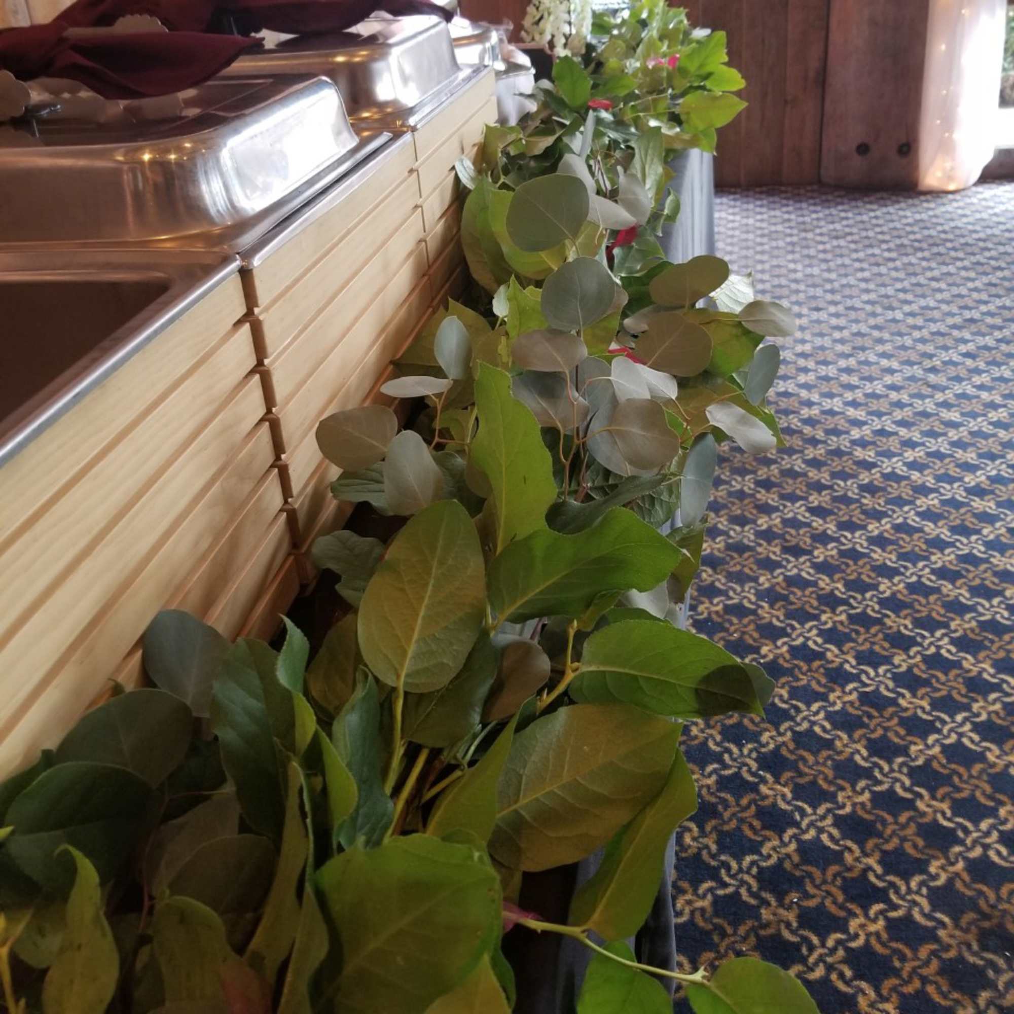 Green foliage garland draped along metal containers in a room