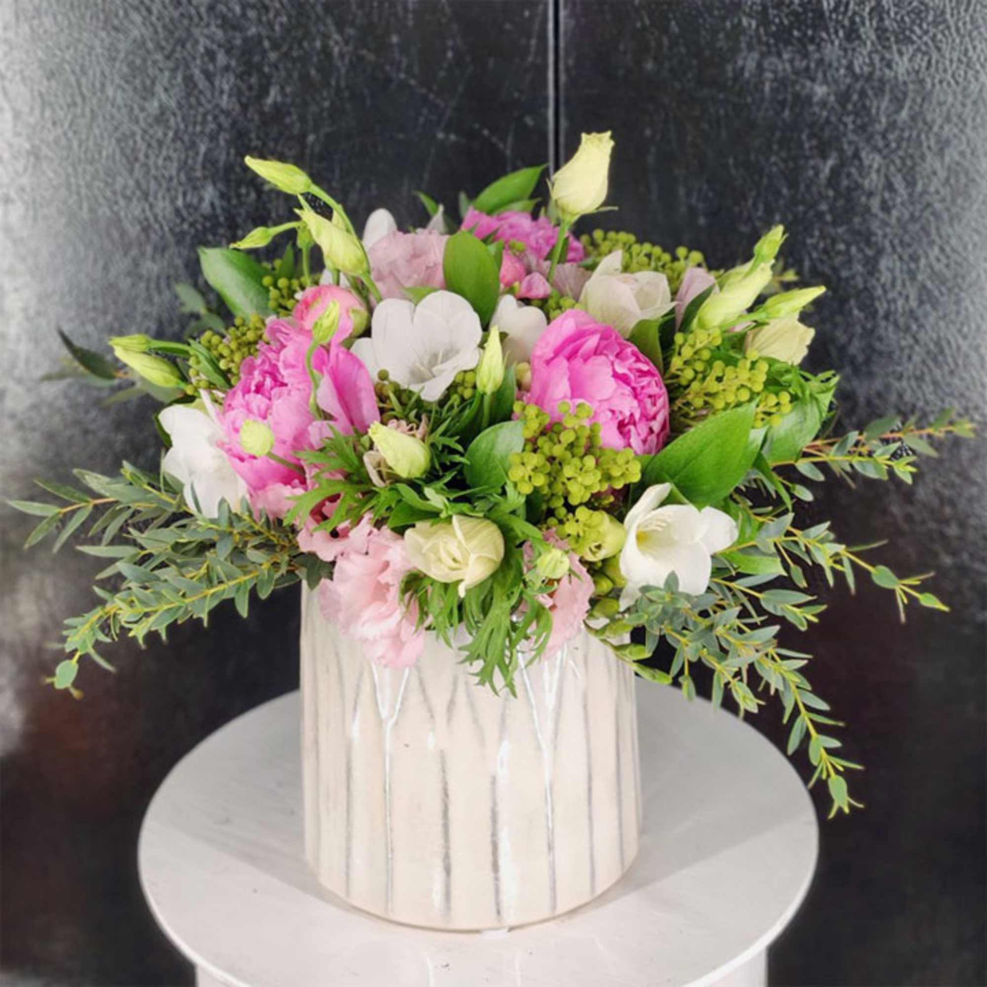 Pink and white floral arrangement in a white vase