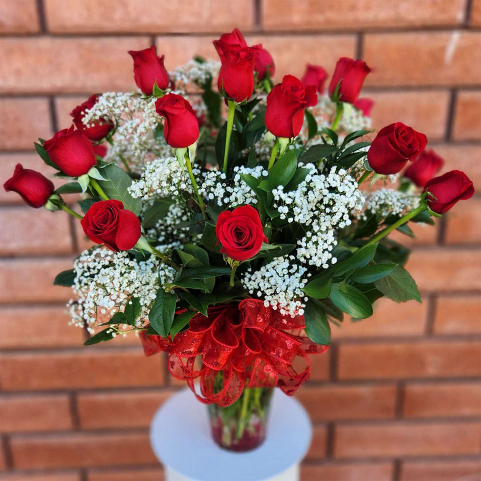 Bouquet of red roses with white baby's breath in a glass vase