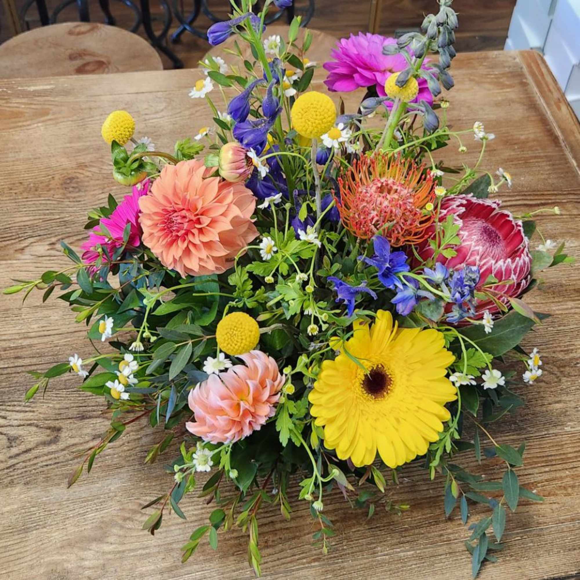 Colorful mixed flower bouquet on a wooden table