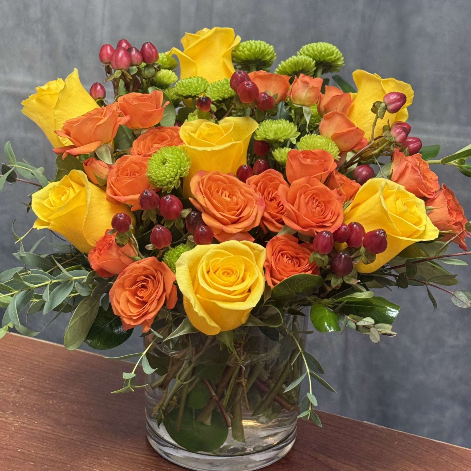 A vibrant and lively arrangement of yellow and orange roses , lime