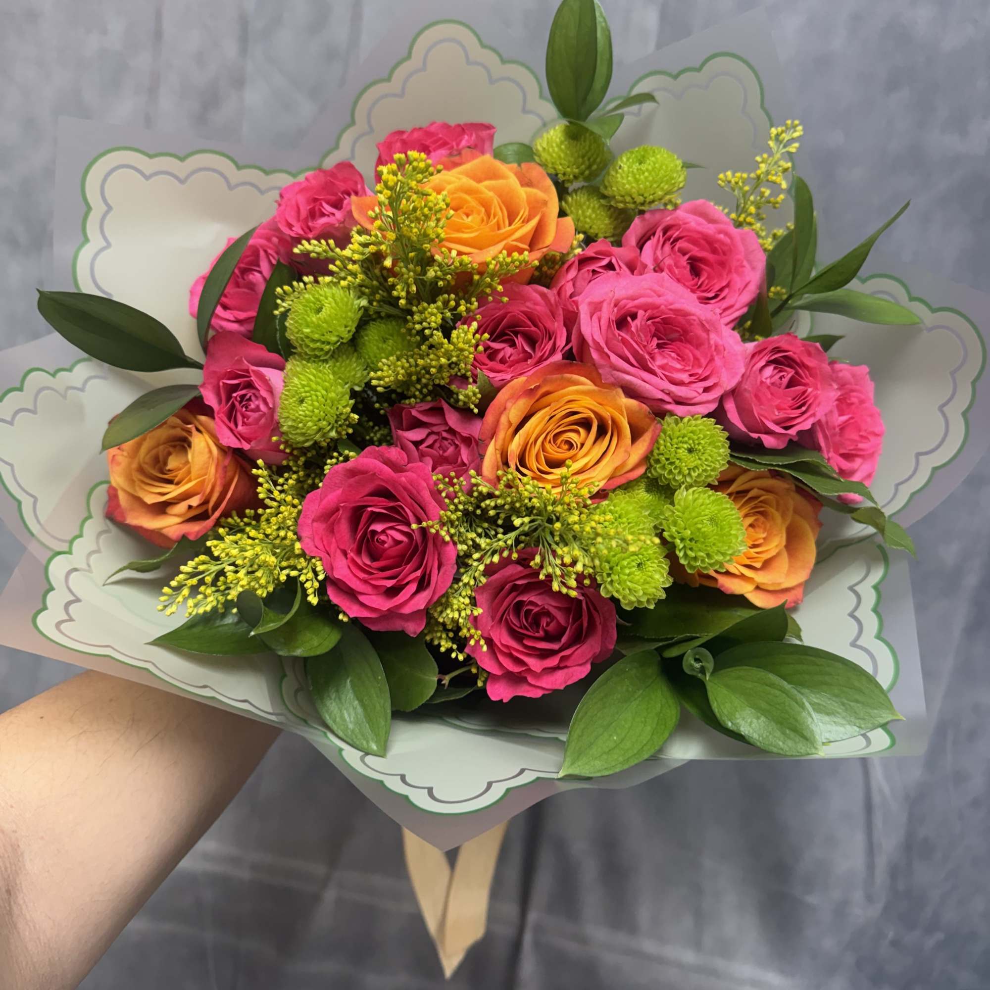 A vibrant mix of hot pink and orange roses accented with cheerful