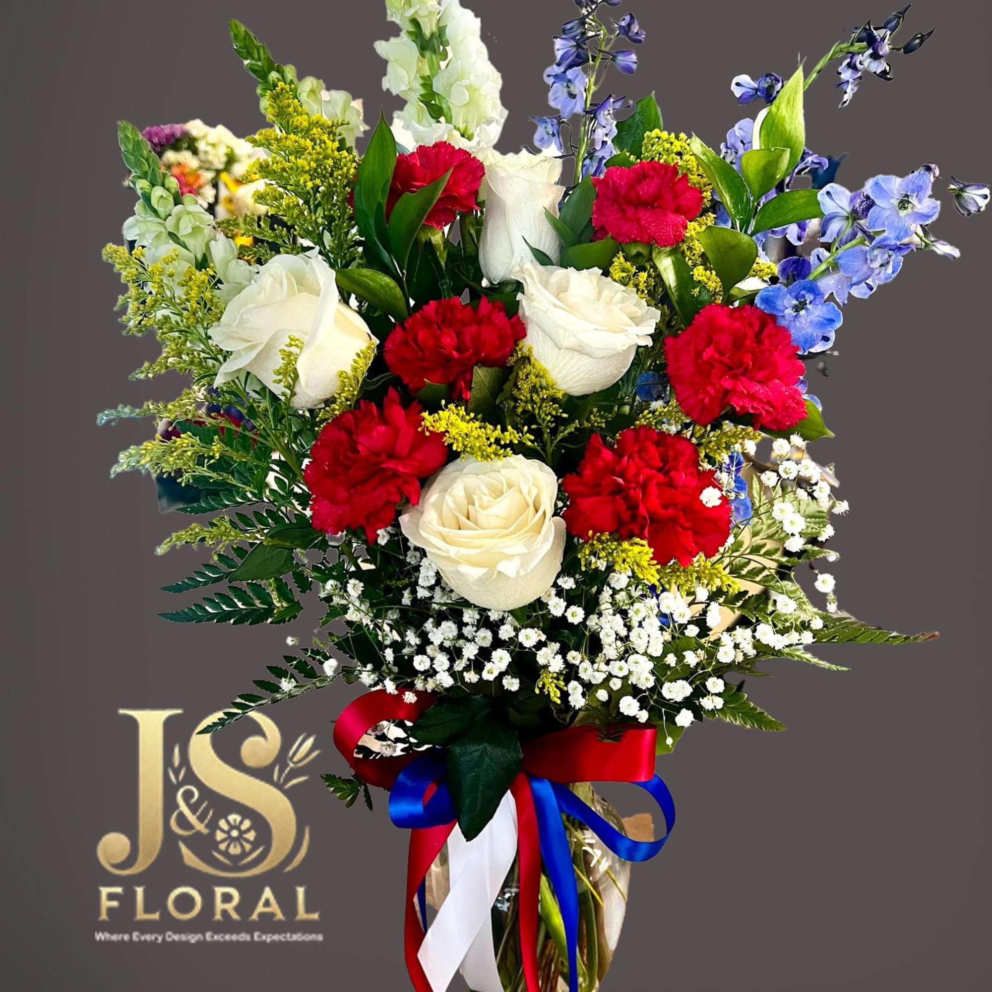 Bouquet of red and white roses with blue flowers in a glass vase
