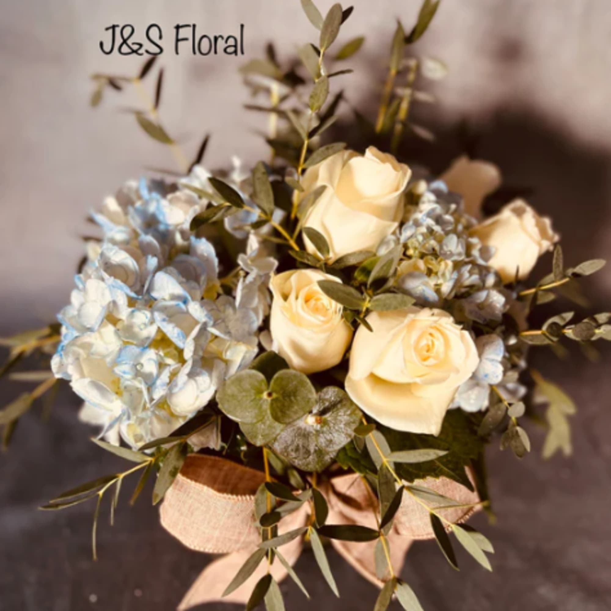 Bouquet of cream roses and pale blue hydrangeas with ribbon