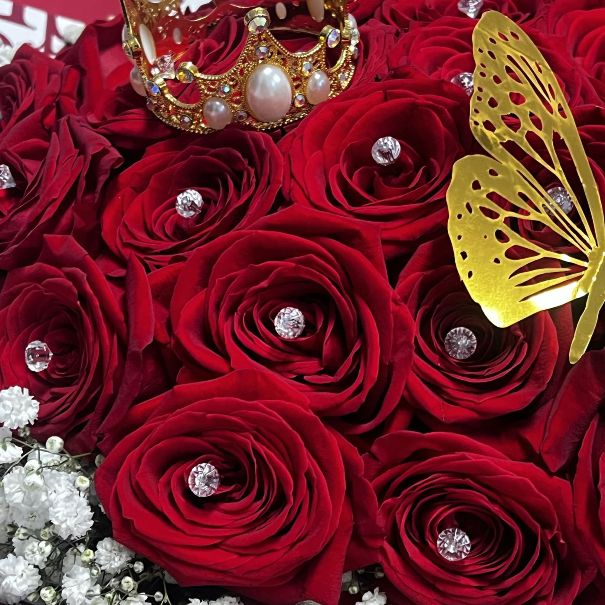 Red roses with a jeweled crown and gold butterfly decoration