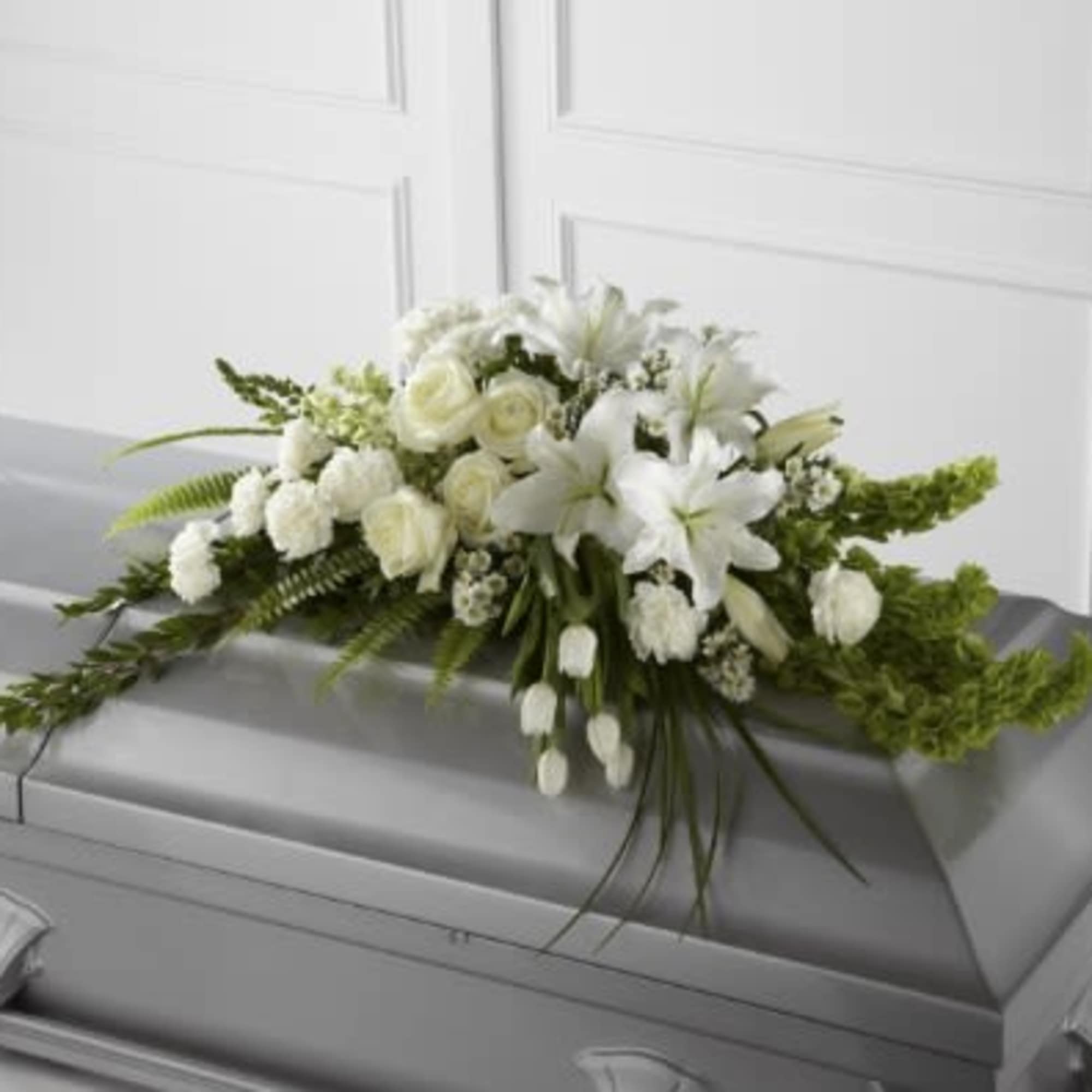 White floral spray on a gray casket