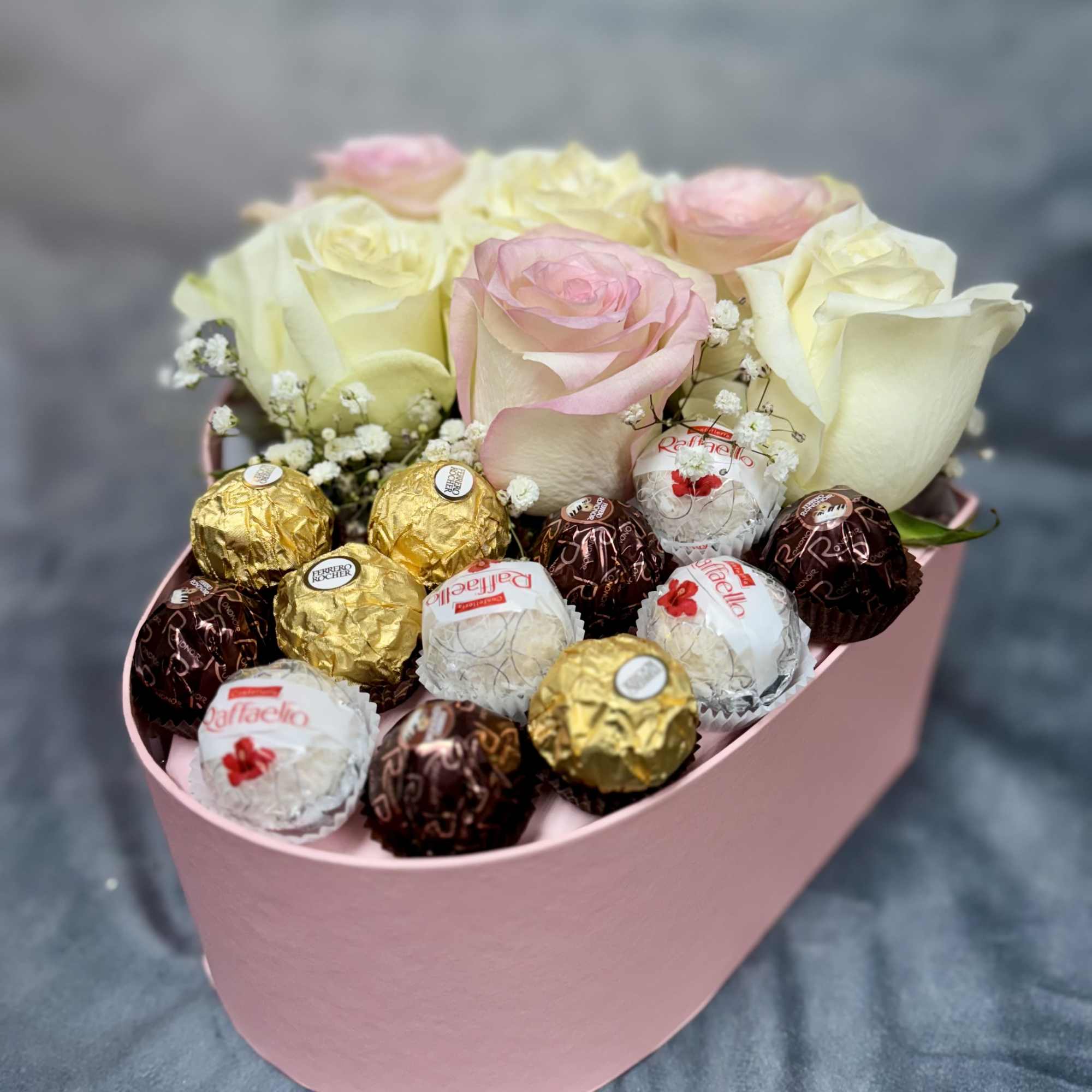 Pink and cream roses in a pink box with assorted chocolates