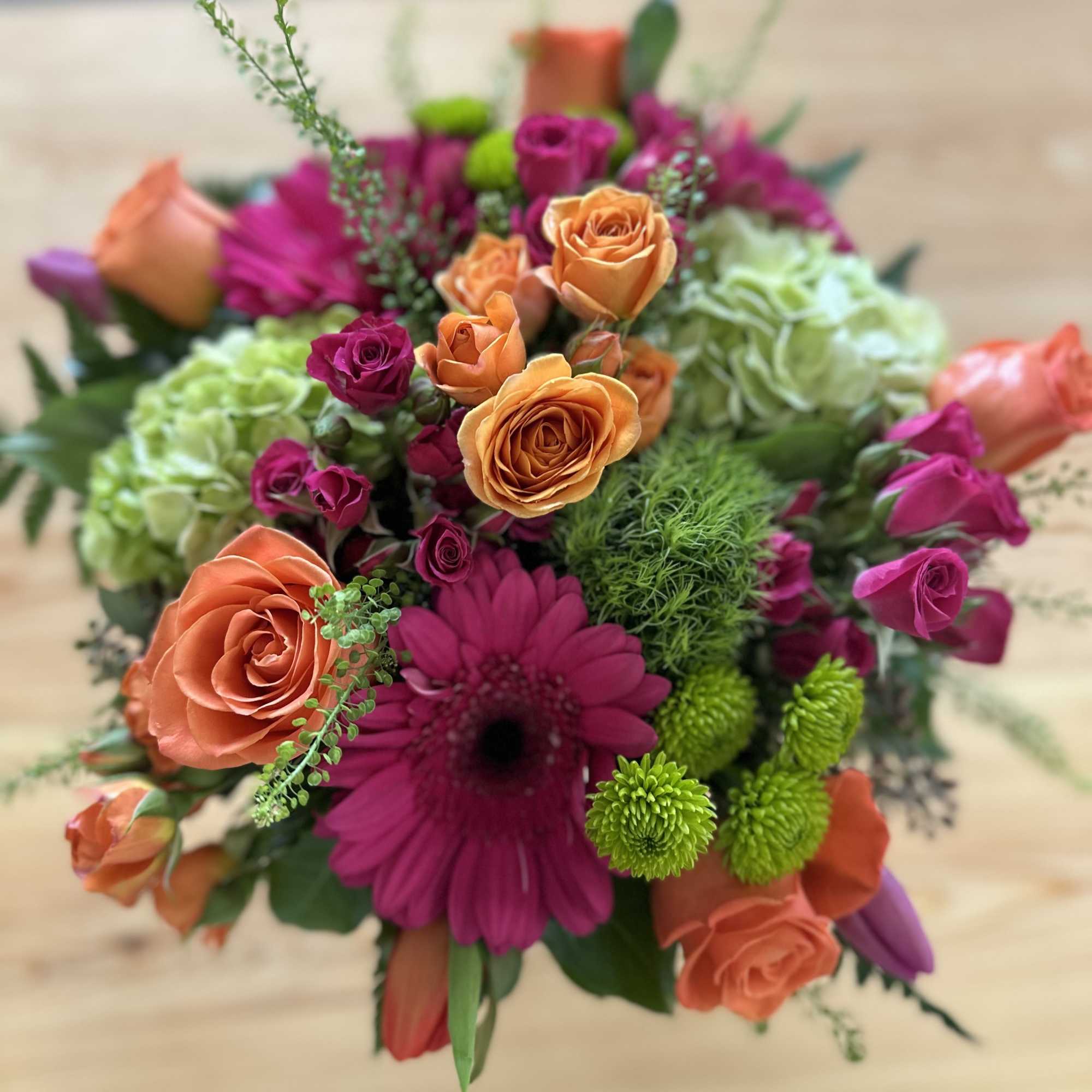 Bouquet of orange and magenta roses with a pink daisy