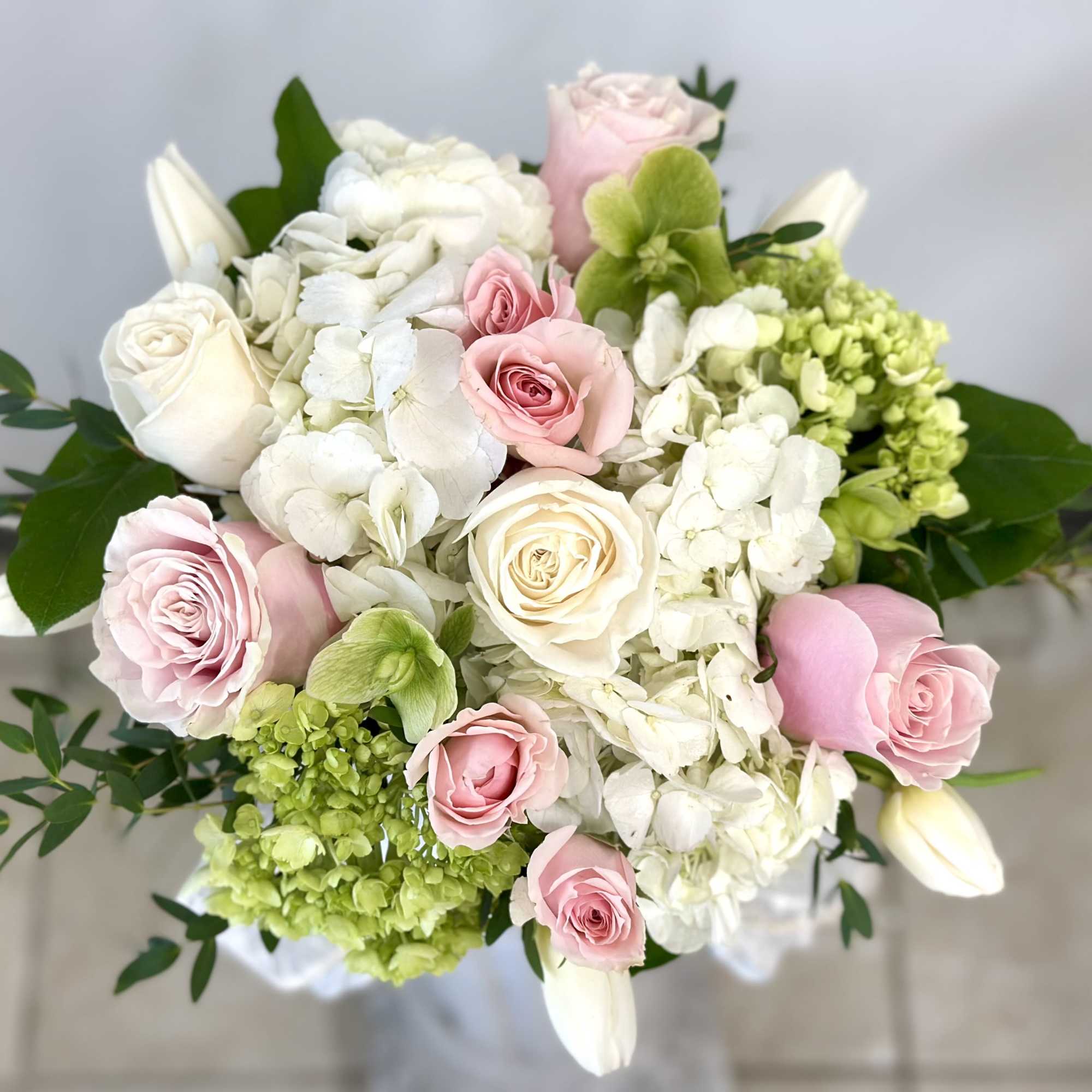 Bouquet of pink and white roses with white hydrangeas and green blooms