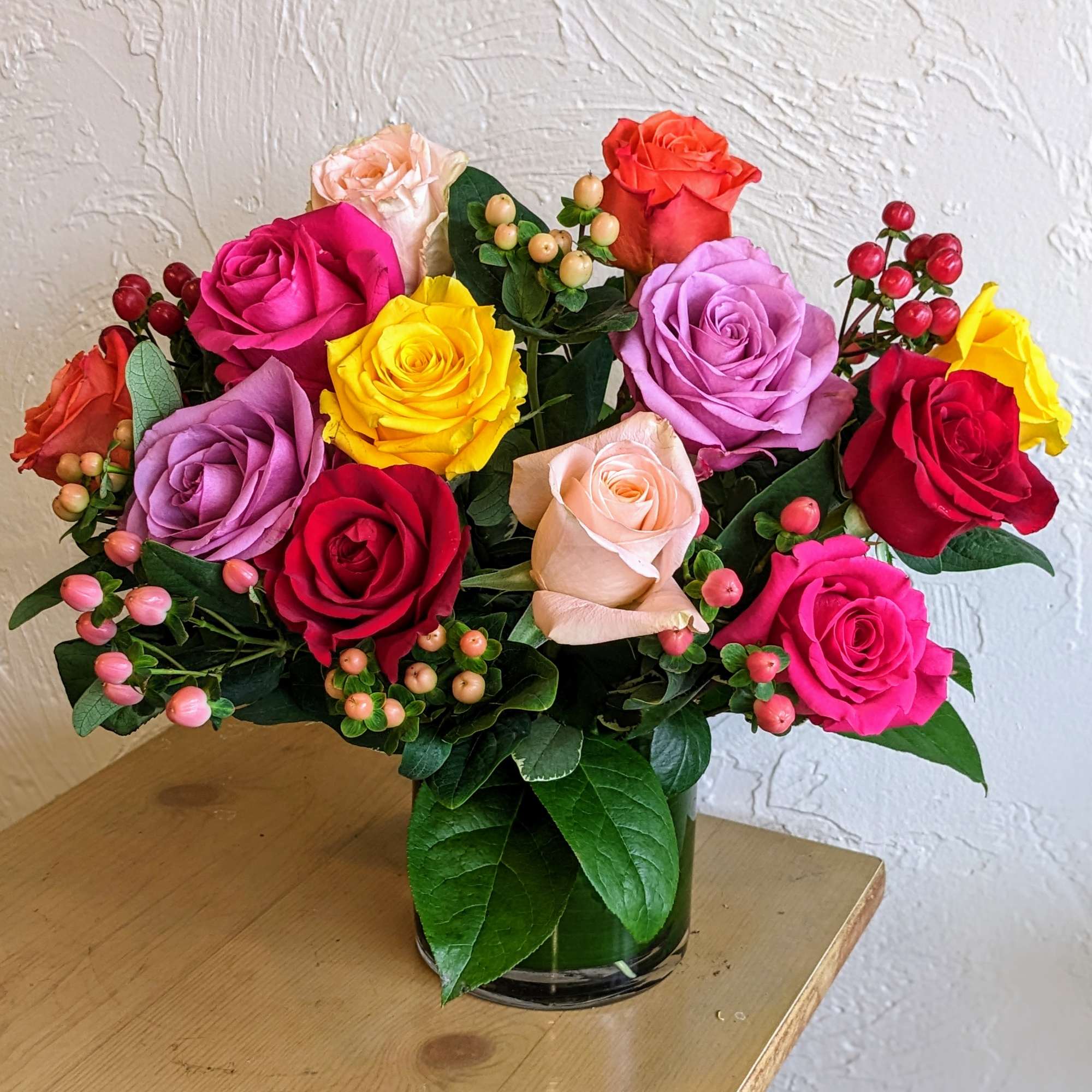 Colorful roses arranged in a clear glass vase