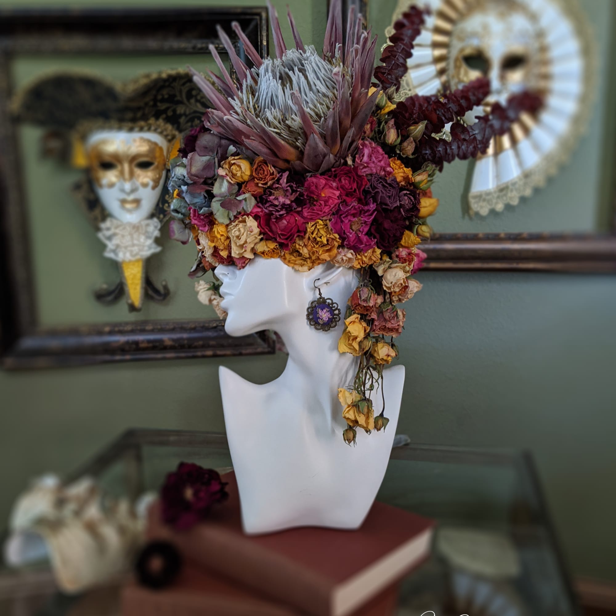 Floral headpiece on a white mannequin bust with dried flowers and feathers