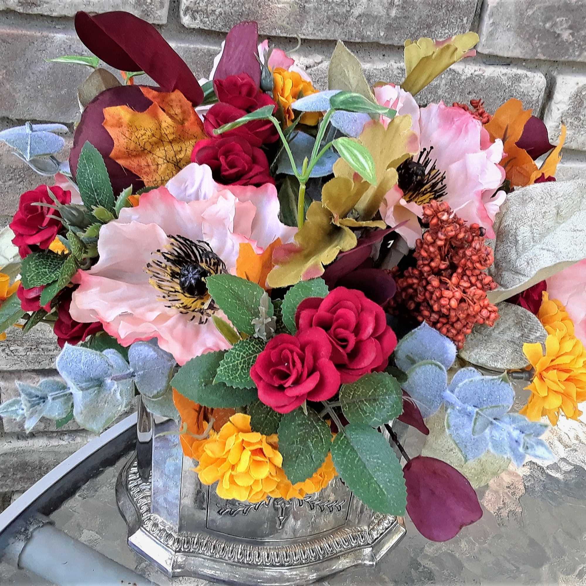 Colorful bouquet of artificial flowers in a silver vase