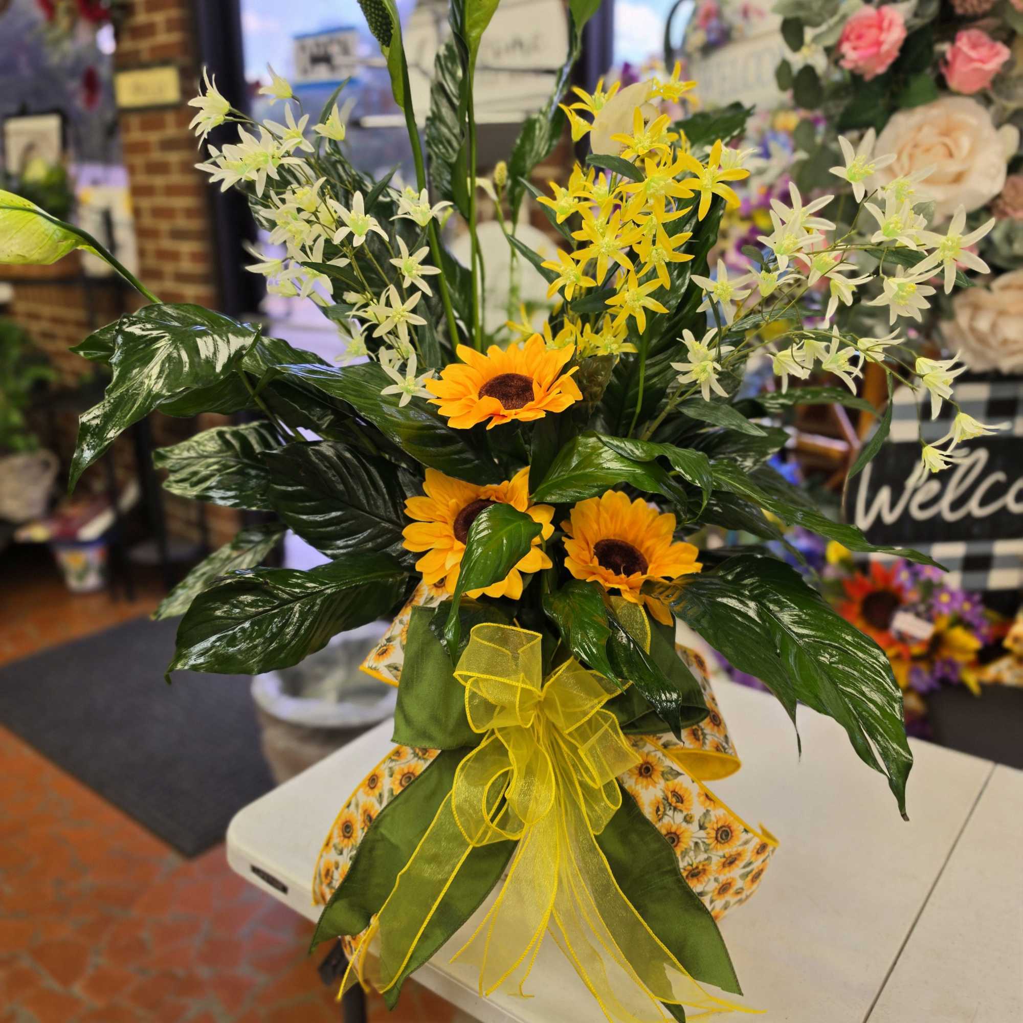 Three bright sunflower blooms take center stage in this cheerful sunflower bouquet