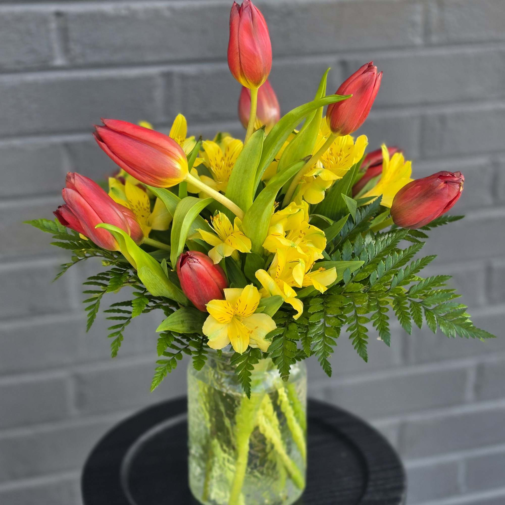 Upright red tulips paired with sunny yellow alstroemeria create a cheerful spring