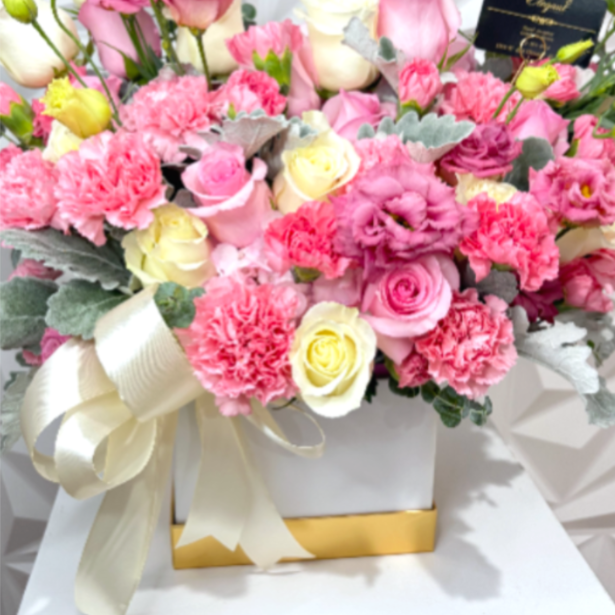 A luxurious floral arrangement designed in a modern white box, featuring a