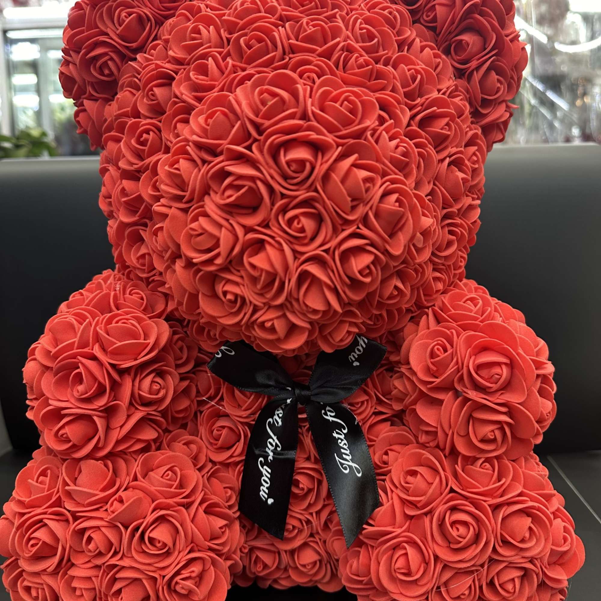 Red rose teddy bear with a black ribbon bow