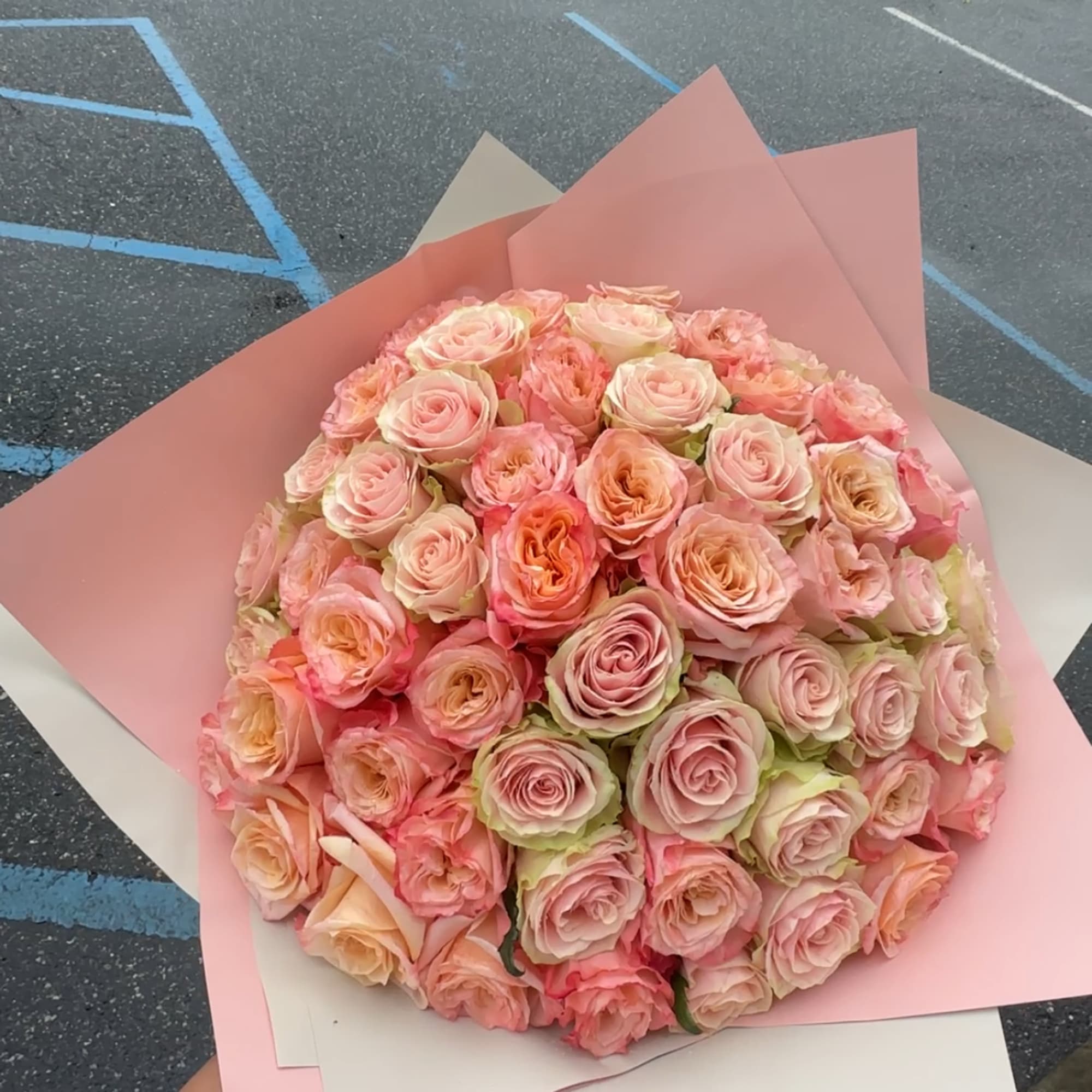 Large bouquet of pale pink and peach roses wrapped in pink paper, photo 2 of 2