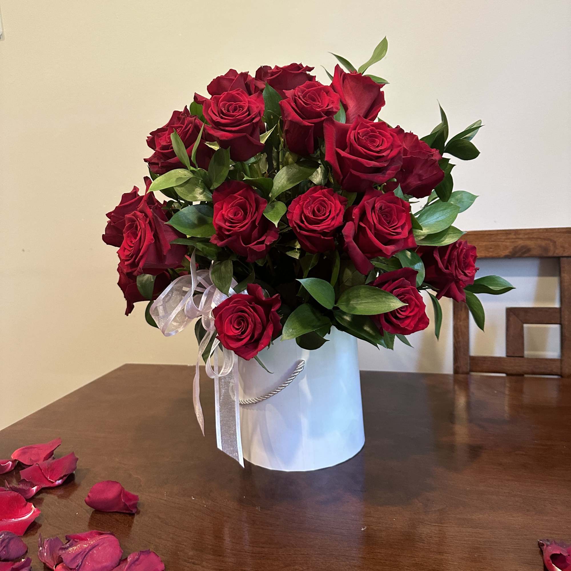 Bouquet of red roses in a white hatbox with a ribbon