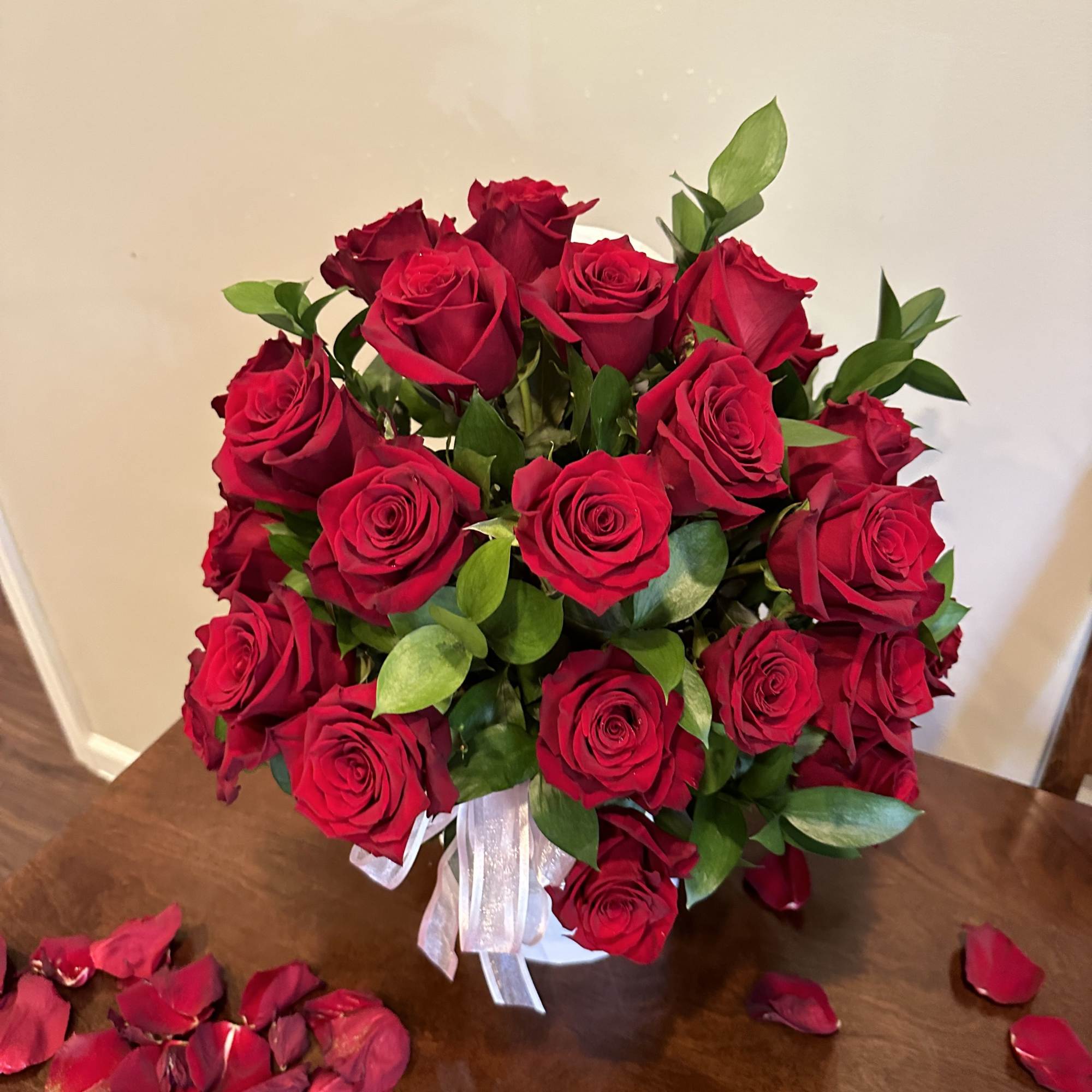 Bouquet of red roses with a white ribbon in a vase