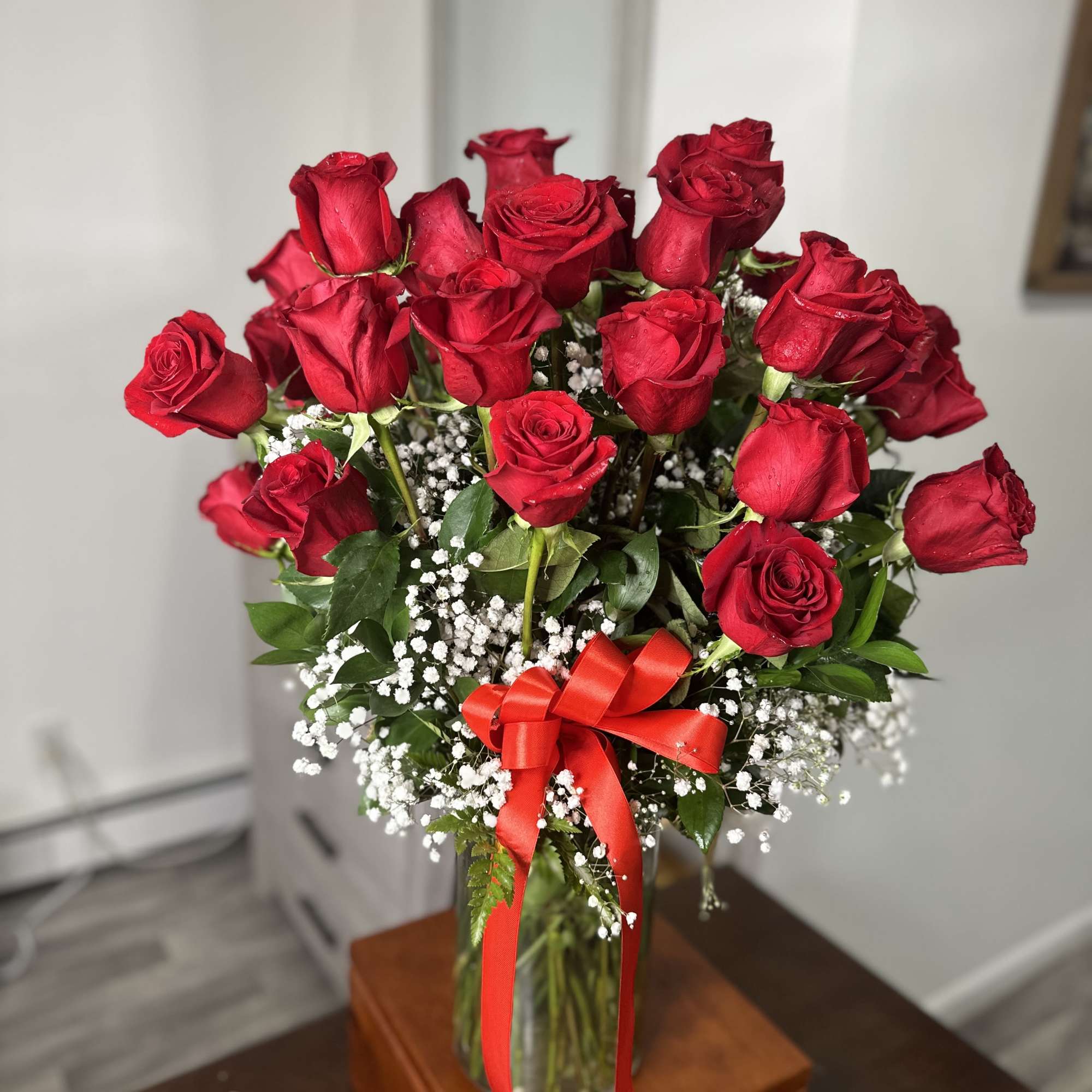 Bouquet of red roses in a glass vase with a red ribbon, photo 2 of 4