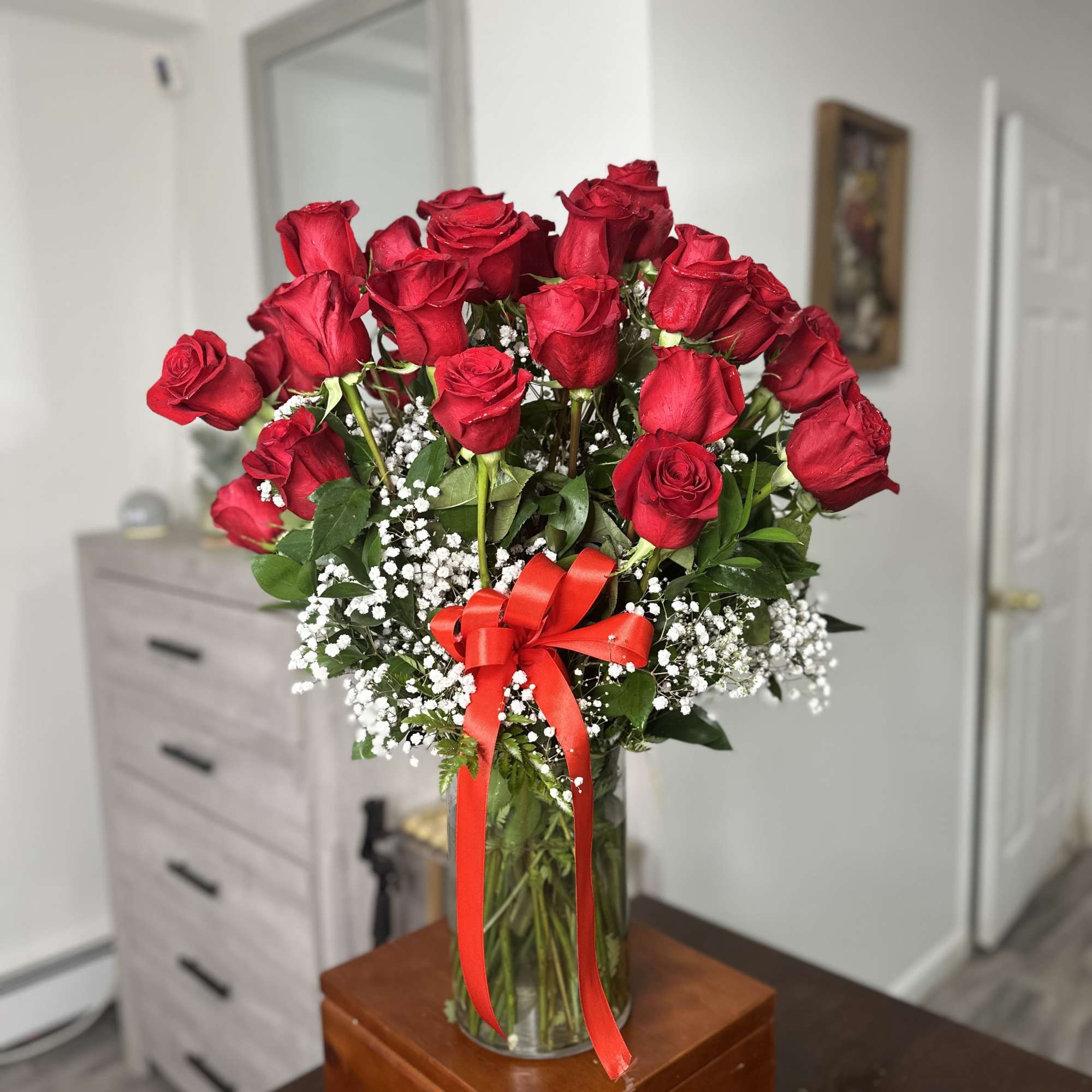 Bouquet of red roses in a glass vase with a red ribbon, photo 3 of 4