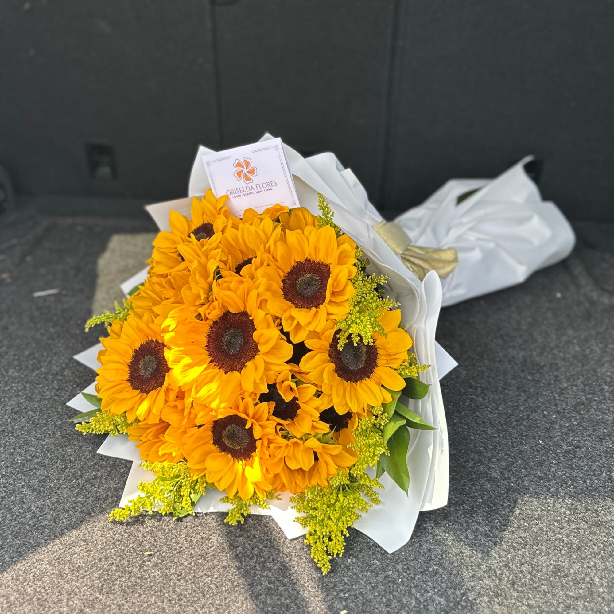 Bouquet of bright yellow sunflowers wrapped in white paper
