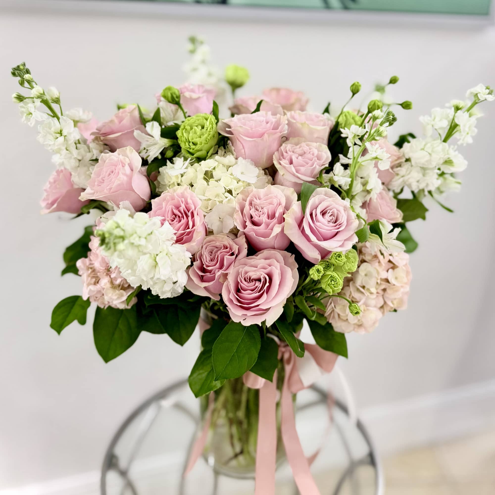 A vase arrangement designed in soft pink tones with a light, balanced