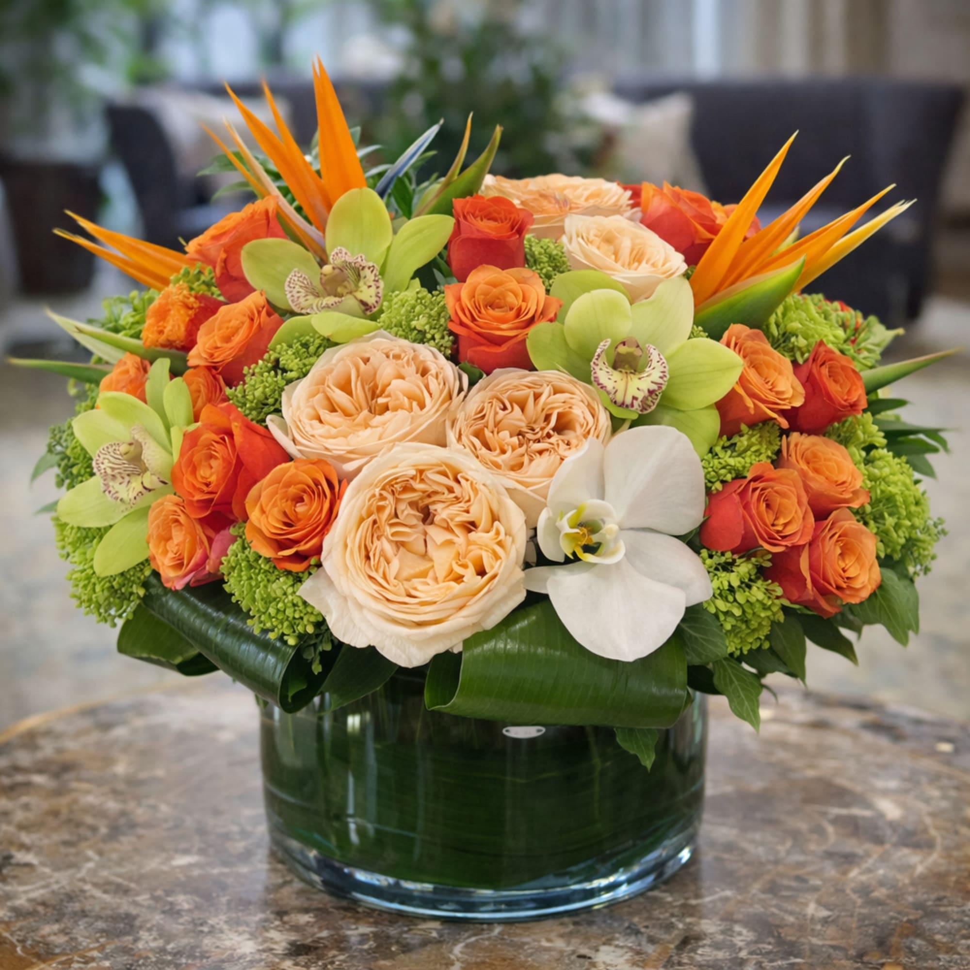 Bright coral and apricot roses cluster around a striking white Phalaenopsis bloom