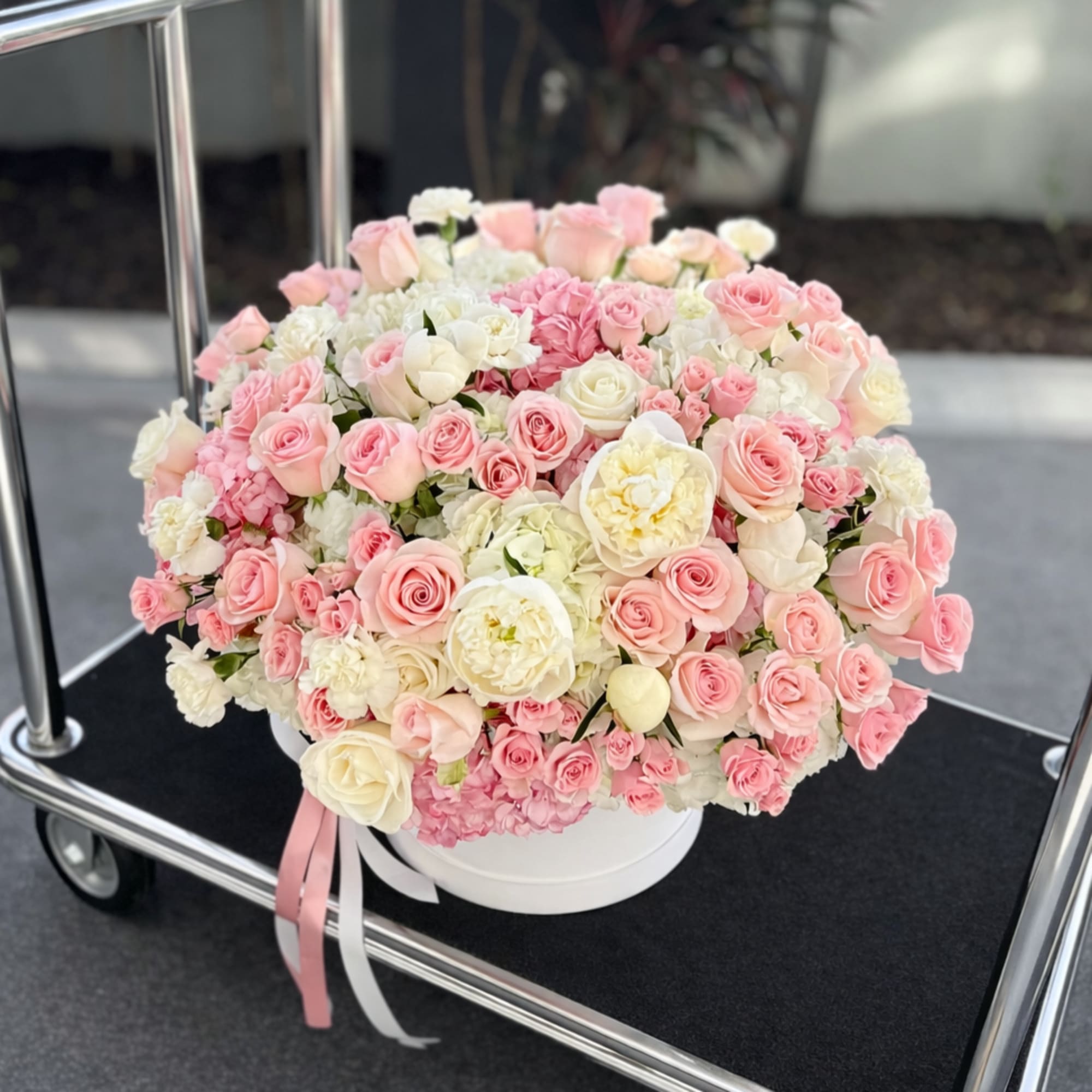 A lush dome of blush pink and ivory roses with soft peach