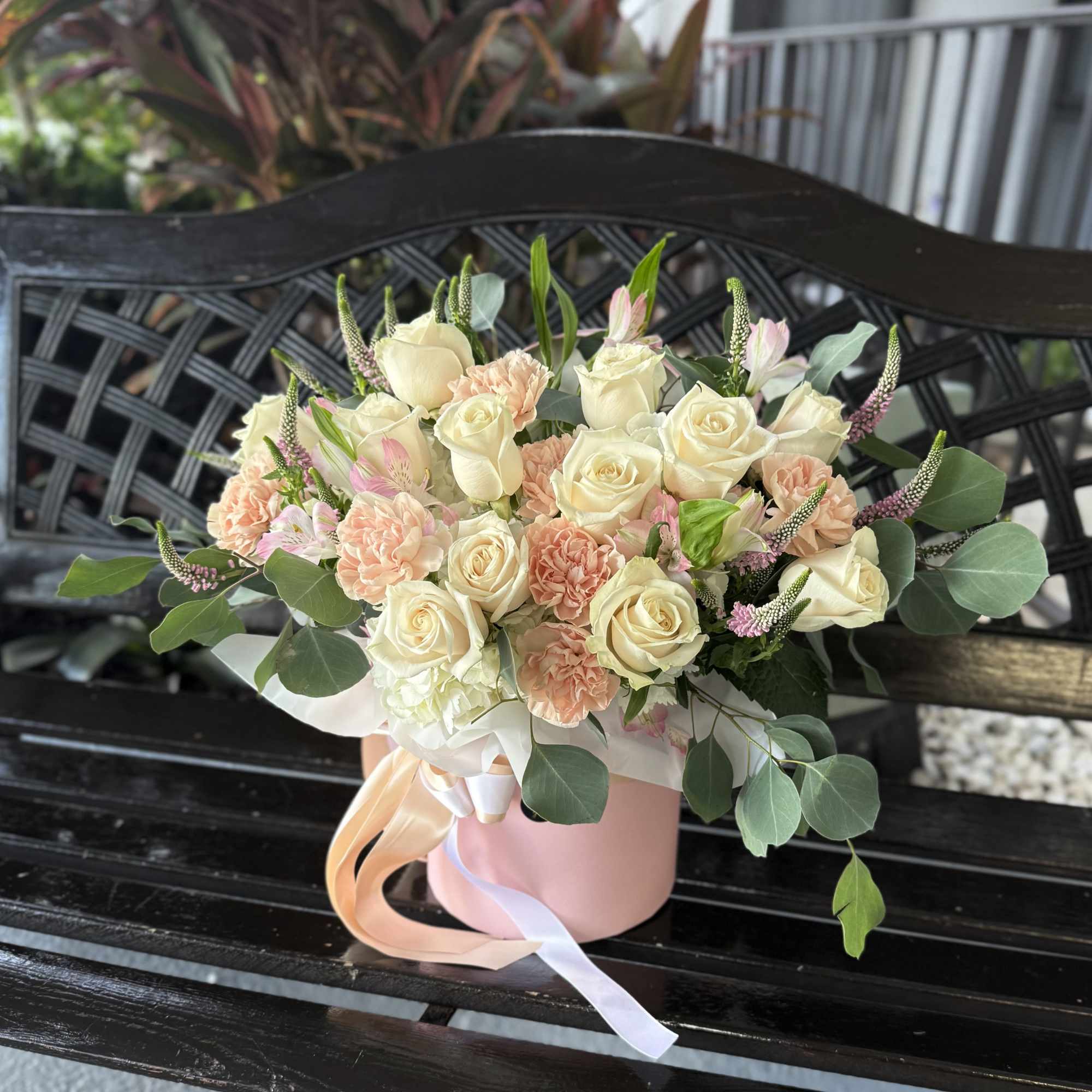 A soft, garden-fresh presentation built around cream roses and blush-to-peach carnations -