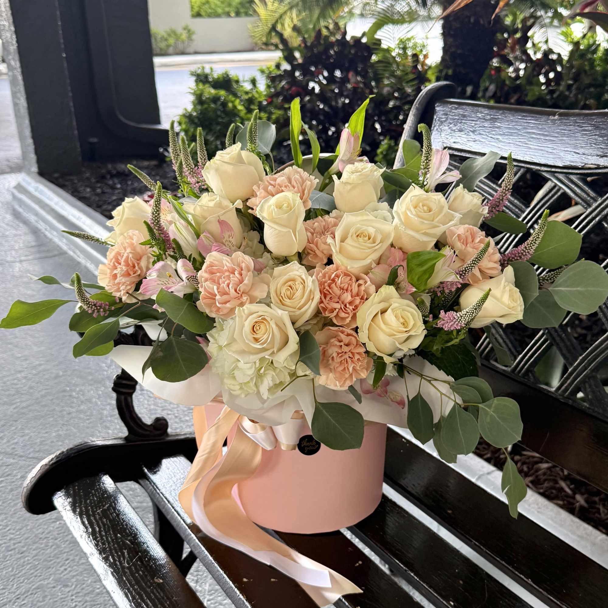 A soft, garden-fresh presentation built around cream roses and blush-to-peach carnations -
