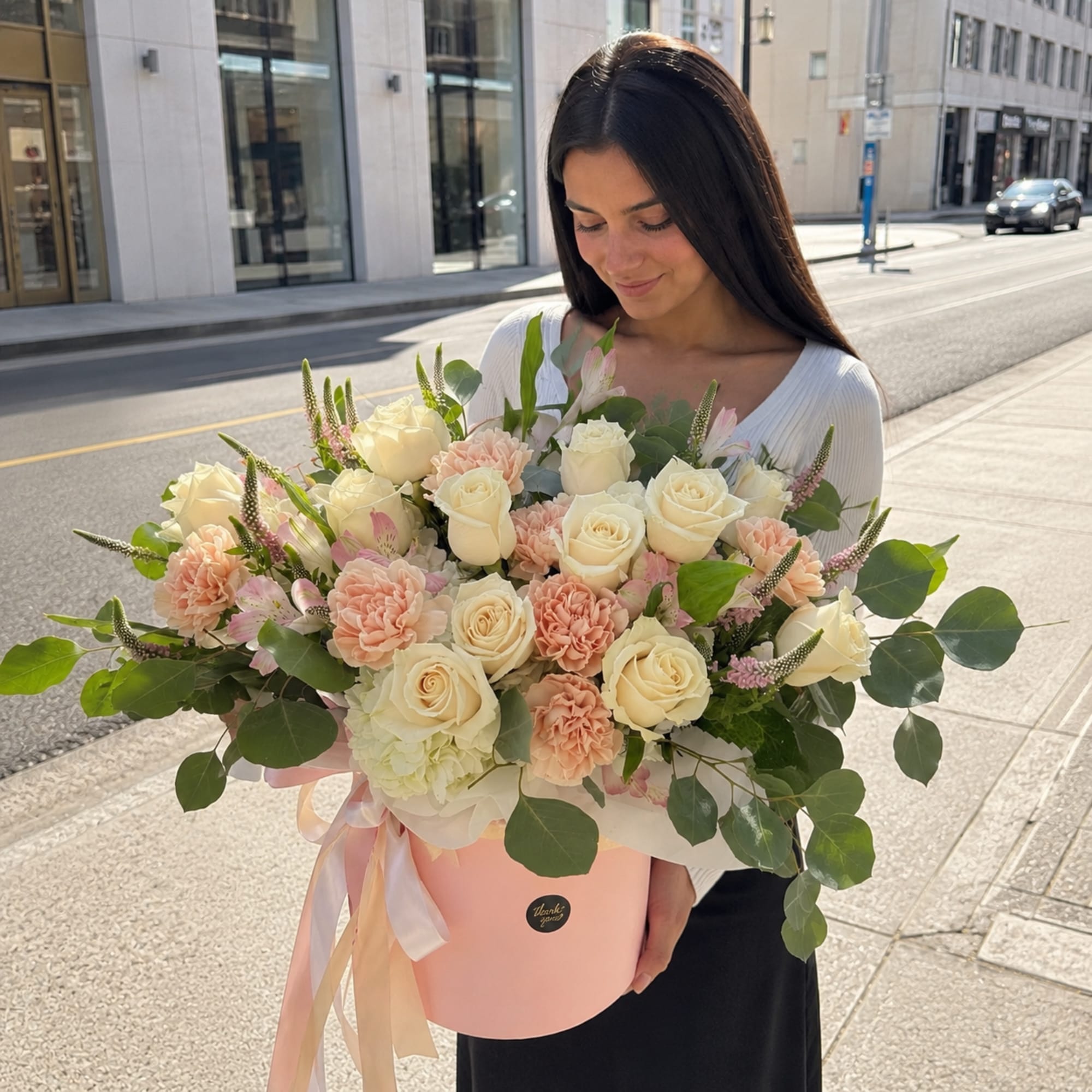 A soft, garden-fresh presentation built around cream roses and blush-to-peach carnations -