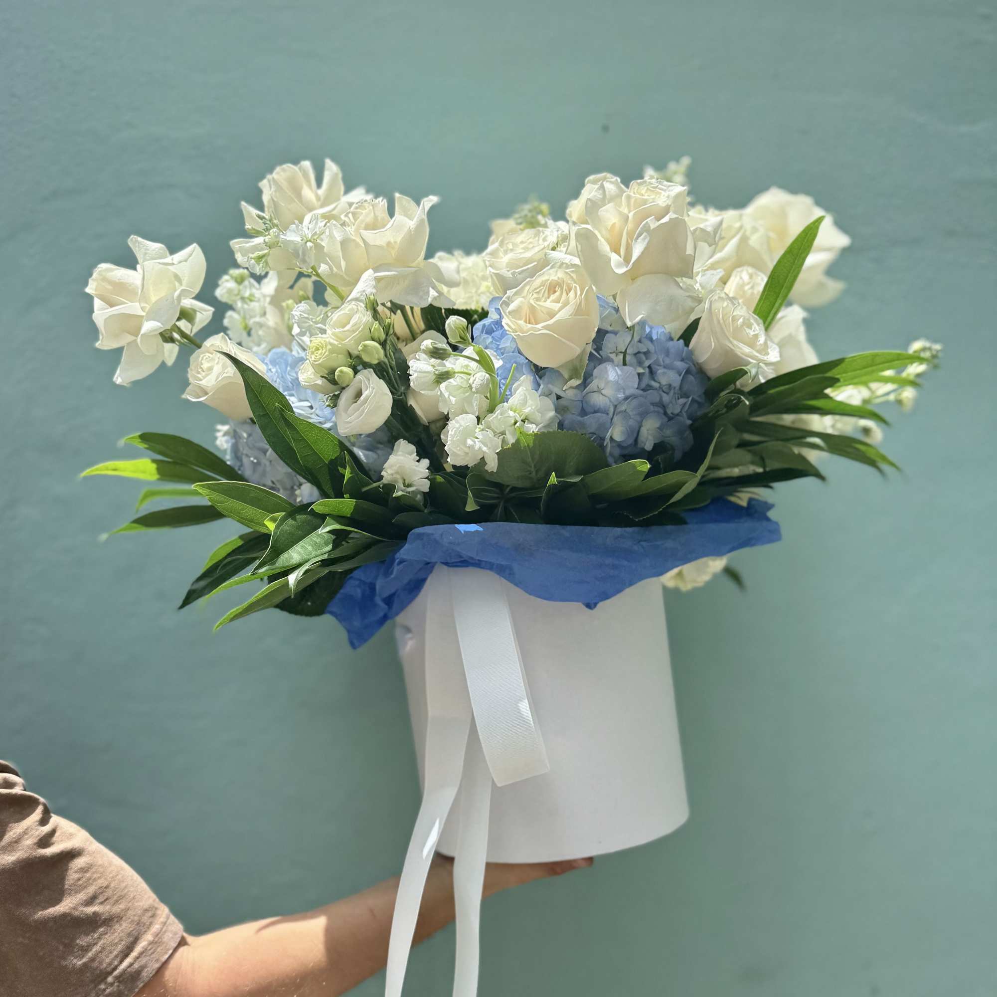 Creamy white roses paired with pale blue hydrangeas create a soft, airy