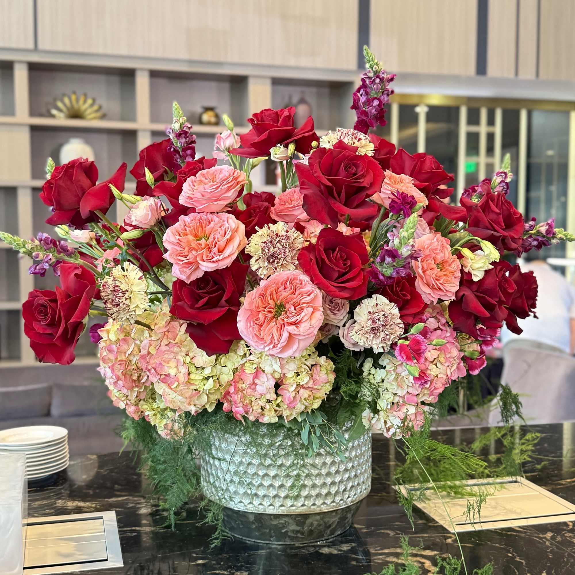 Deep, romantic red roses take center stage in this generous flower arrangement