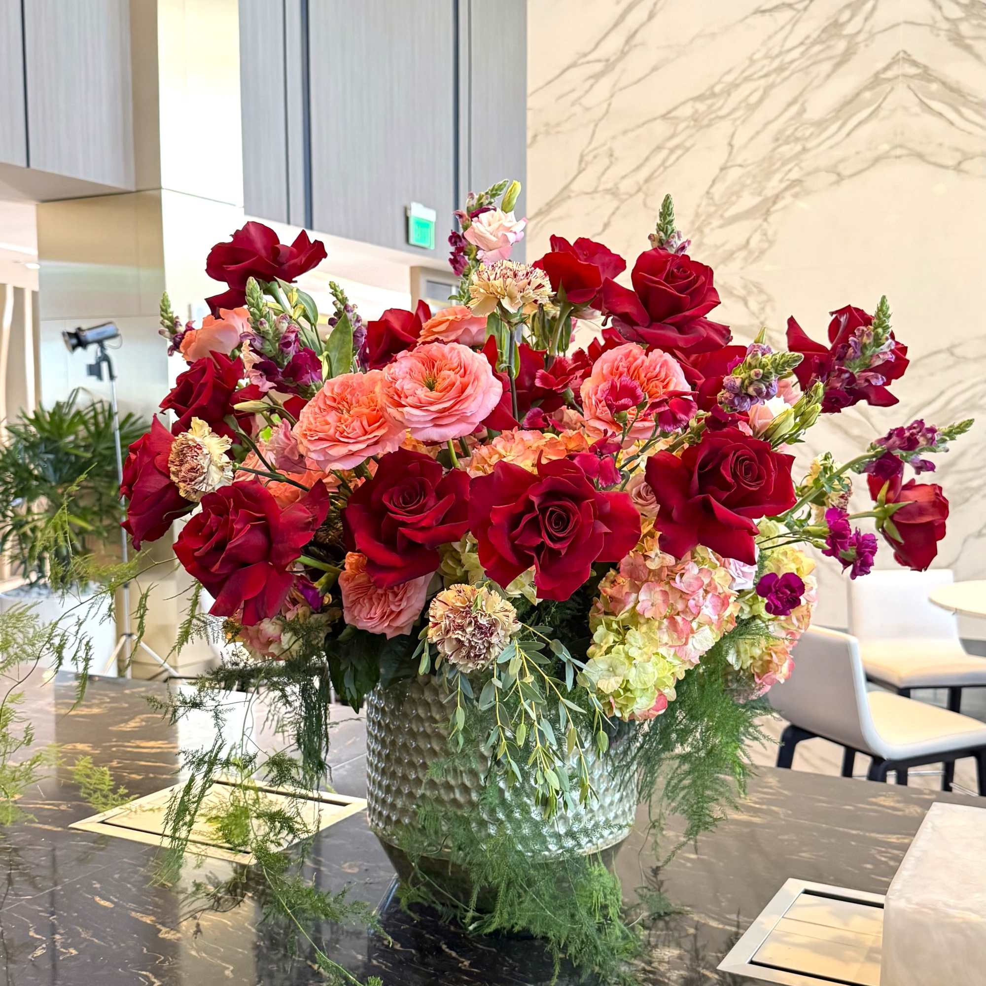 Deep, romantic red roses take center stage in this generous flower arrangement