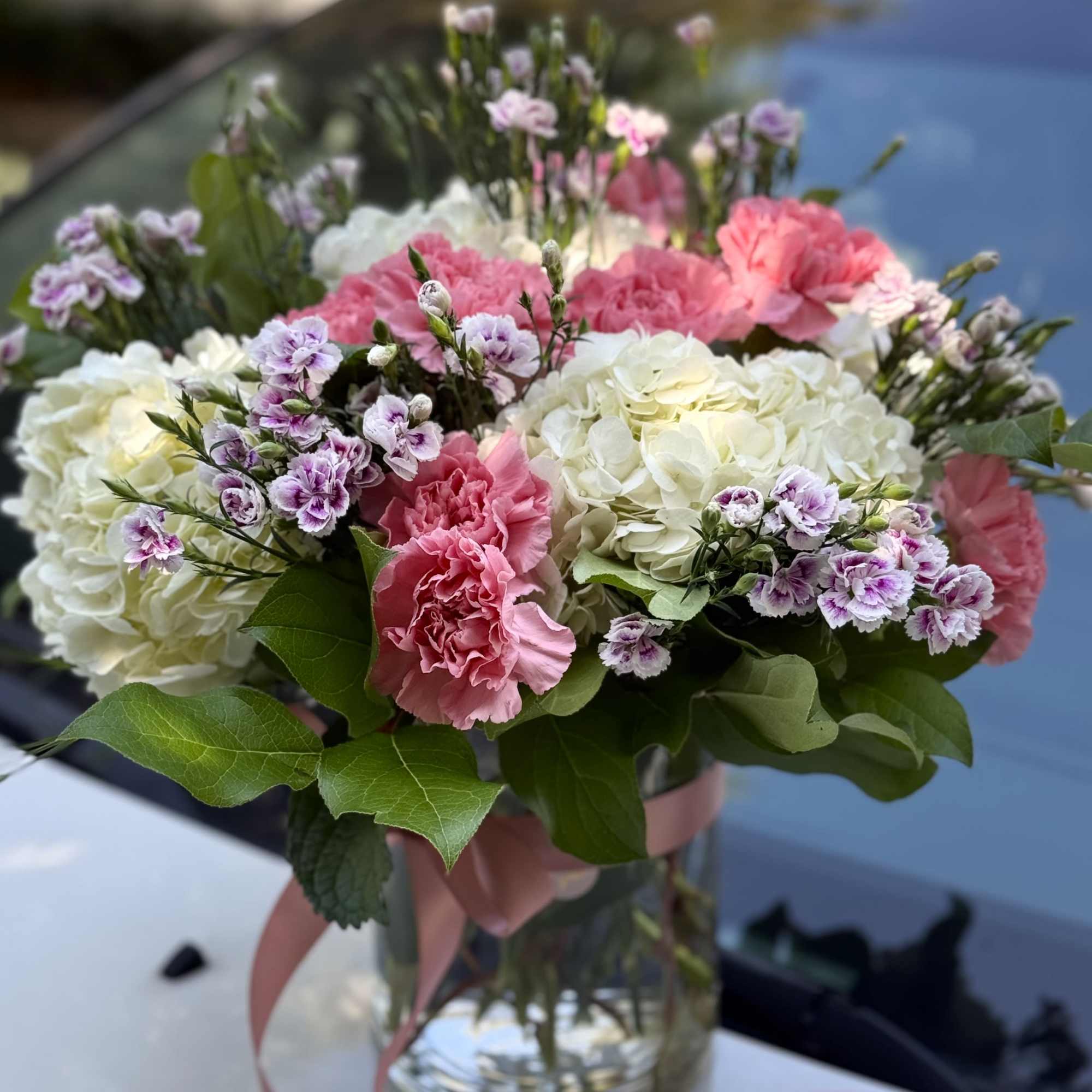 A lush, garden-style bouquet of white and pale green hydrangeas with ruffled