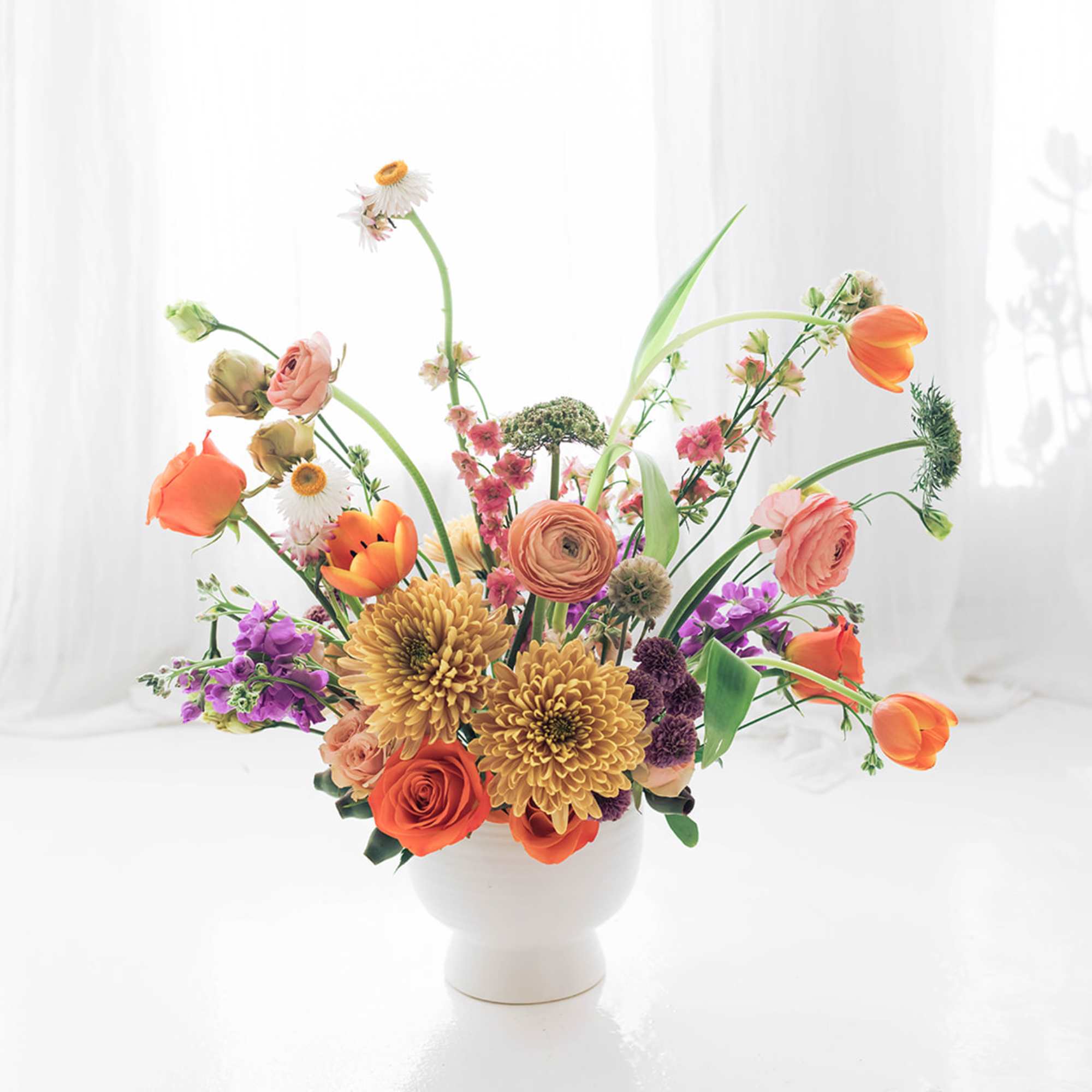 Lovely and vibrant mix of premium bright blooms on a delicate compote