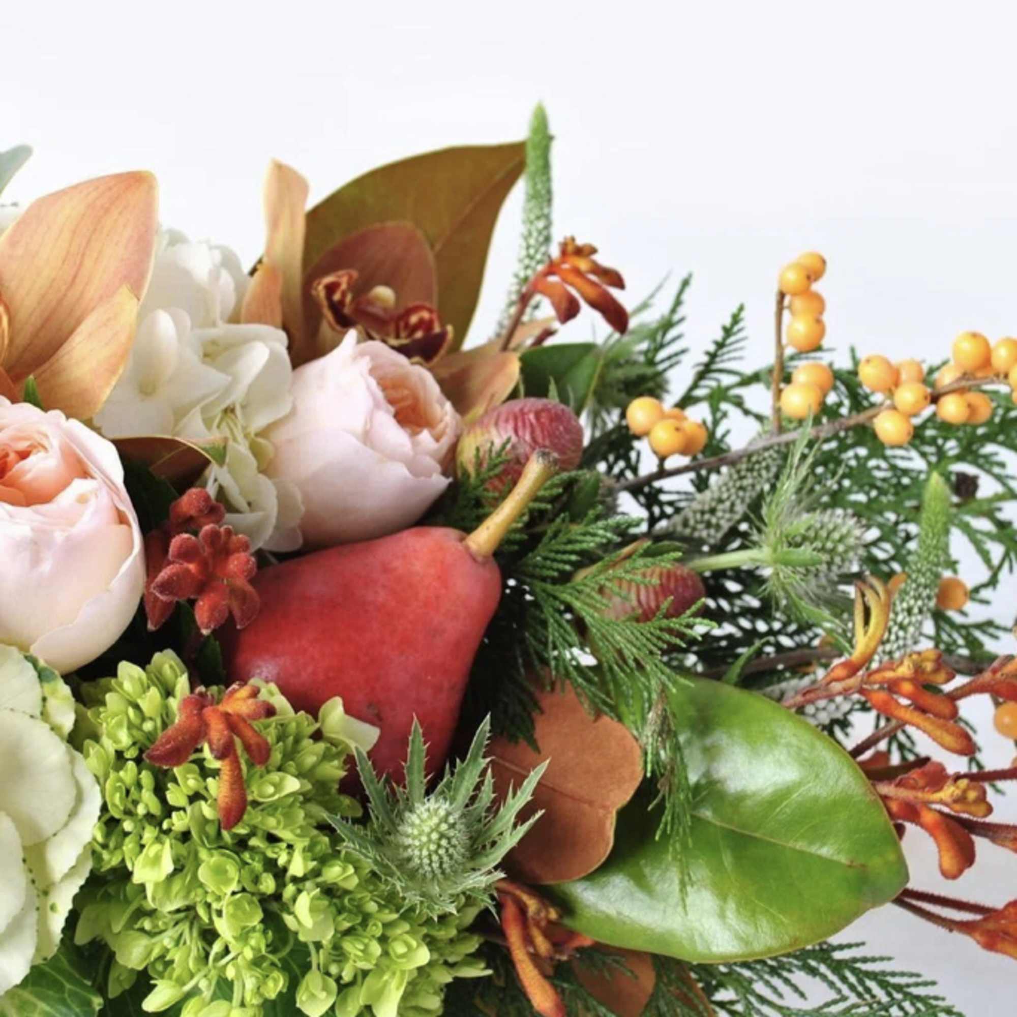 Autumn-toned arrangement with roses, orchids, hydrangeas and decorative pears