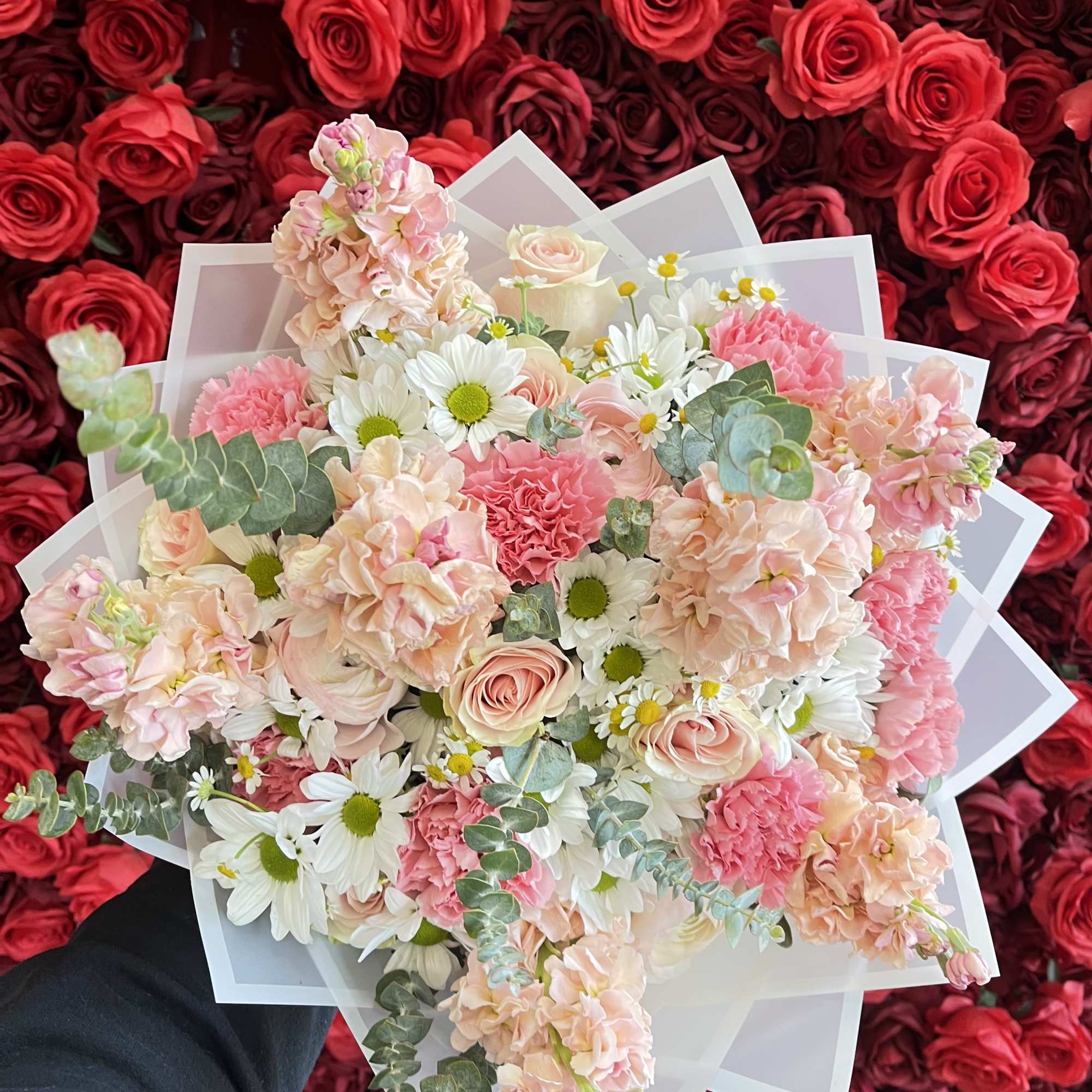 Bouquet of pink and white flowers wrapped in translucent paper