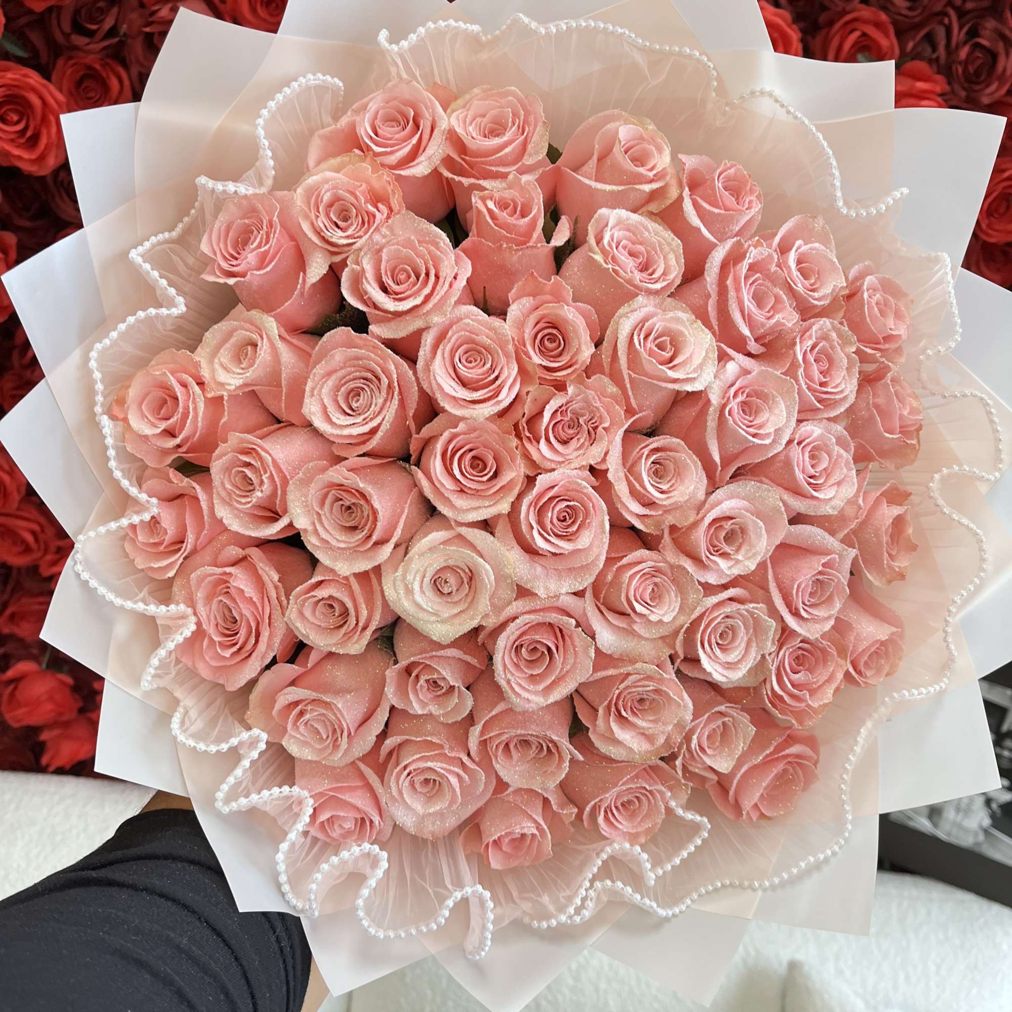 Large bouquet of pink roses wrapped in white paper