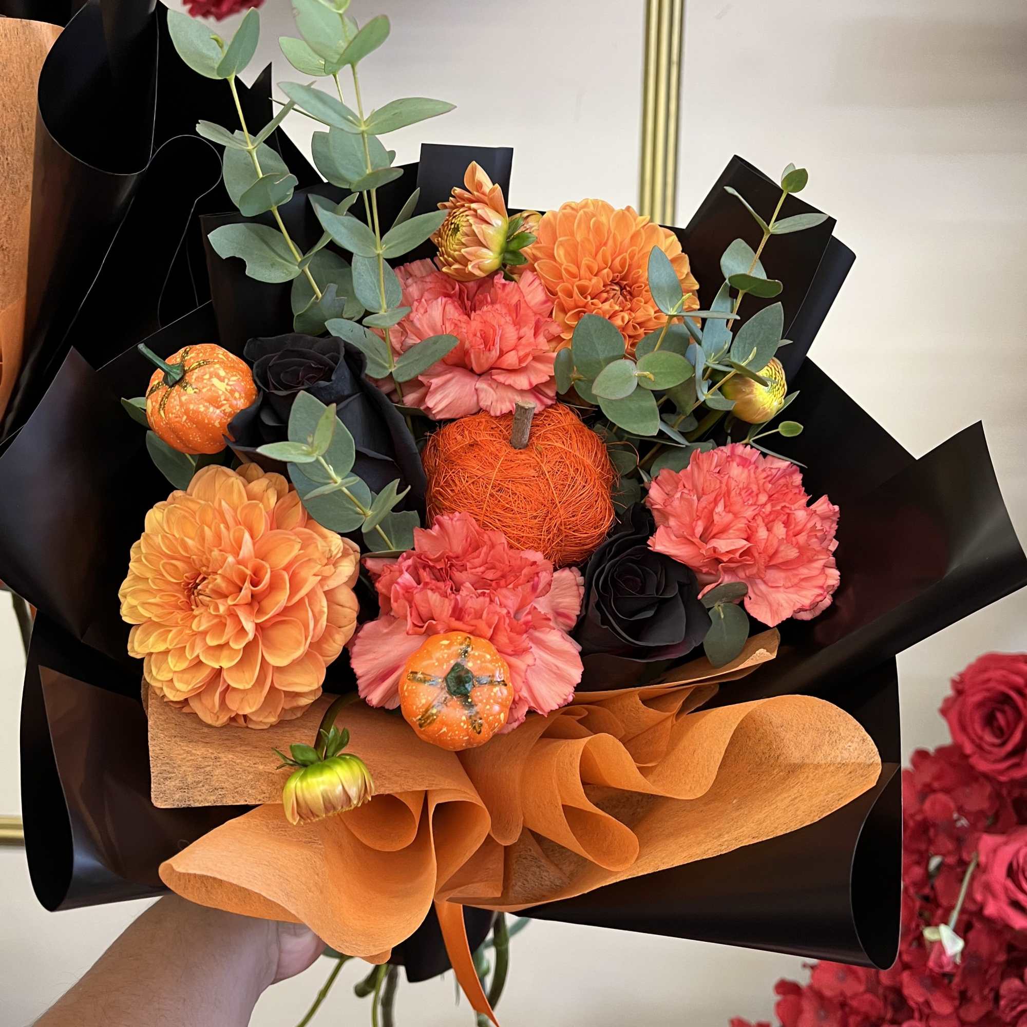 Bouquet of orange and pink flowers with black and orange wrapping