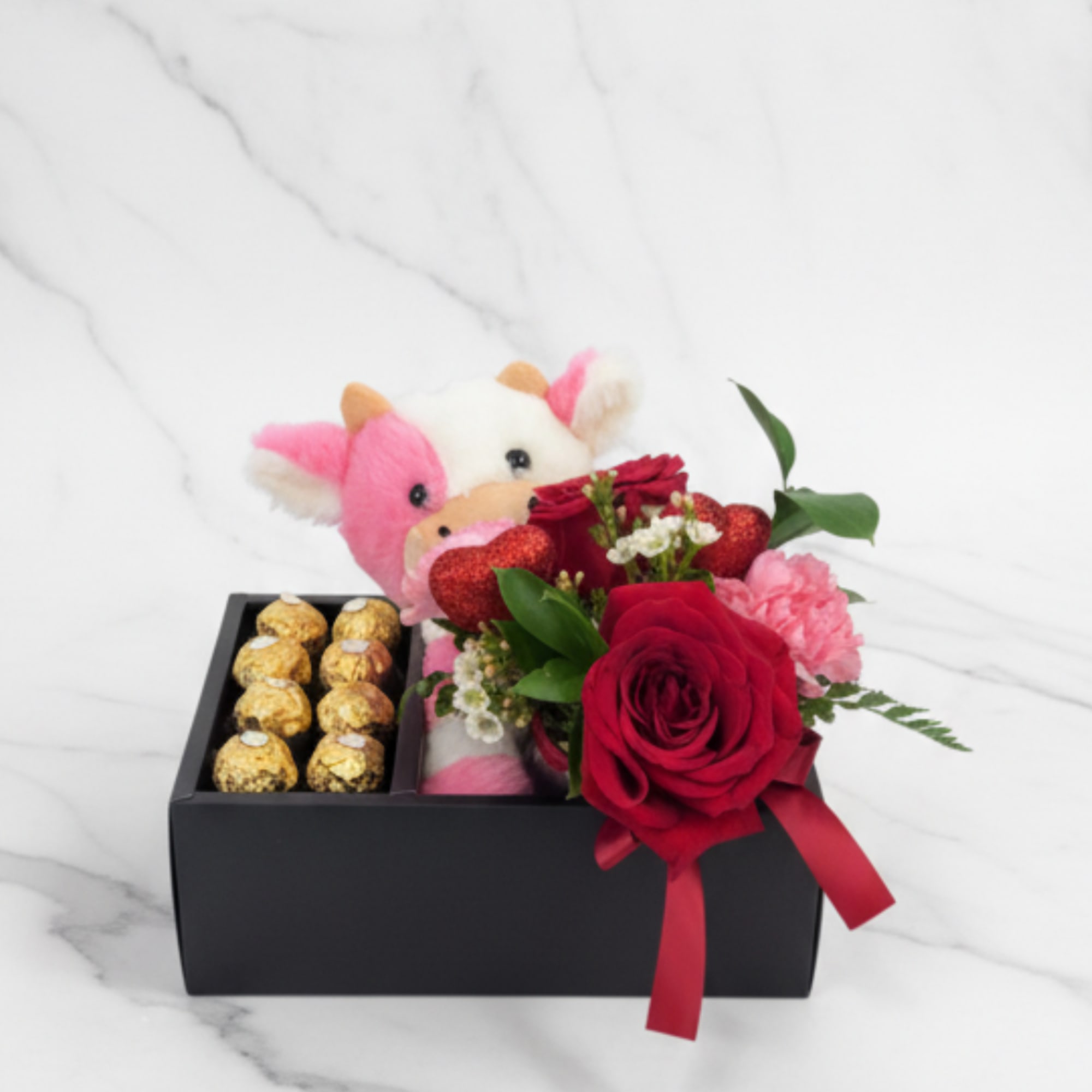 Gift box with a plush cow, red roses, and chocolates