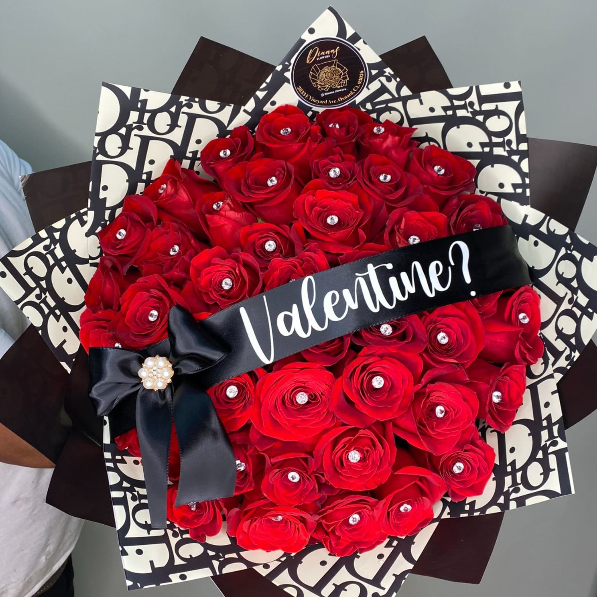 Bouquet of red roses wrapped in black-and-white paper with a Valentine ribbon