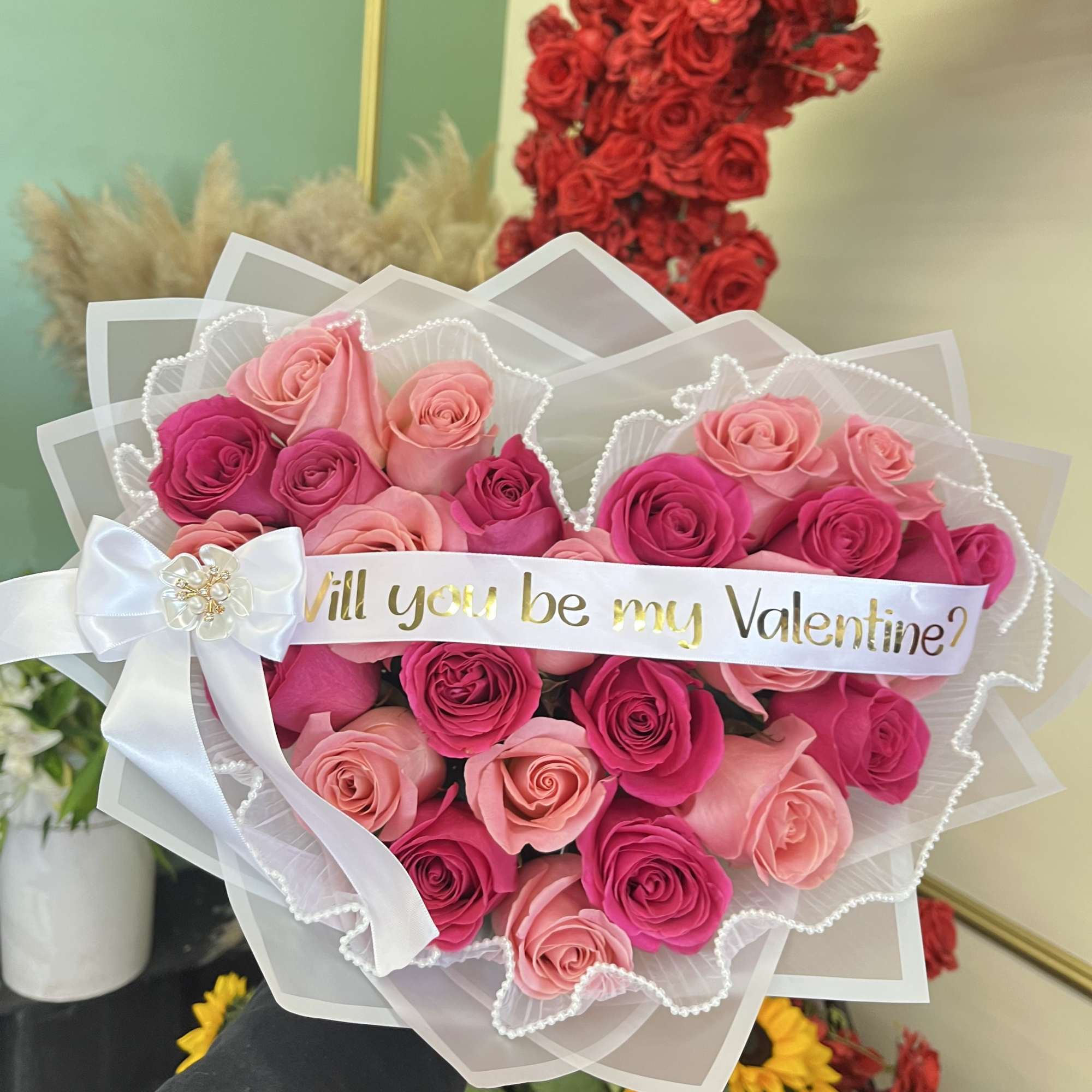 Pink and red rose bouquet with a "Will you be my Valentine?" ribbon