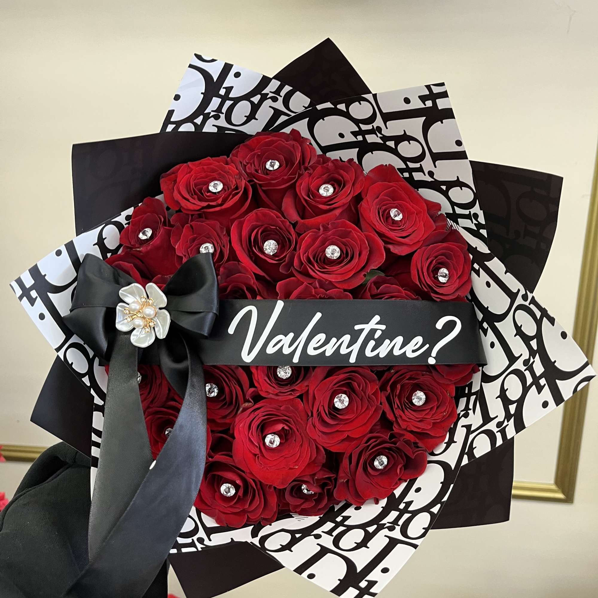 Bouquet of red roses wrapped in black and white paper with a black bow